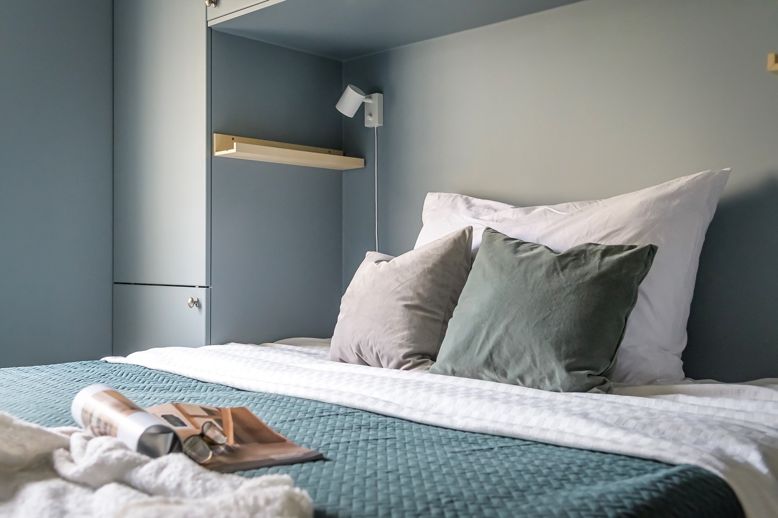 De plassbygde skapene rundt sengen er malt i samme farge som veggene, som gir et svært gjennomført uttrykk. Galleribilde