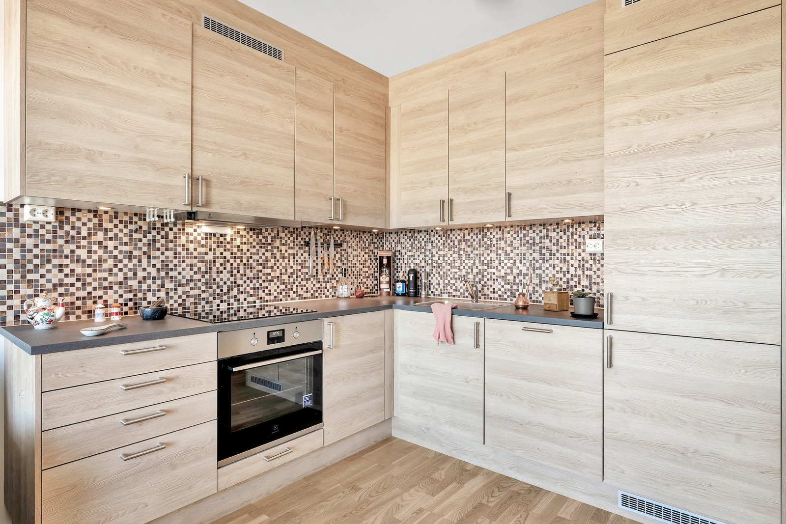 Kjøkkenet er innredet med glatte fronter og benkeplate i laminat. Det er integrert stekeovn, platetopp, oppvaskmaskin og kjøleskap med fryser. Galleribilde