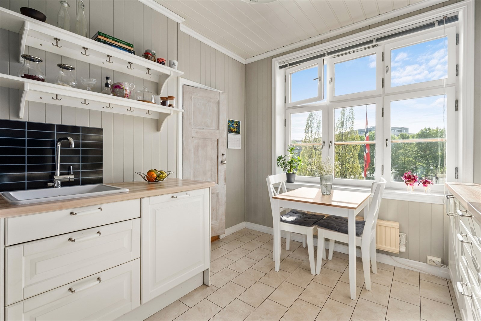 Separat kjøkken med spiseplass og store vindusflater med hyggelig grønt utsyn Galleribilde