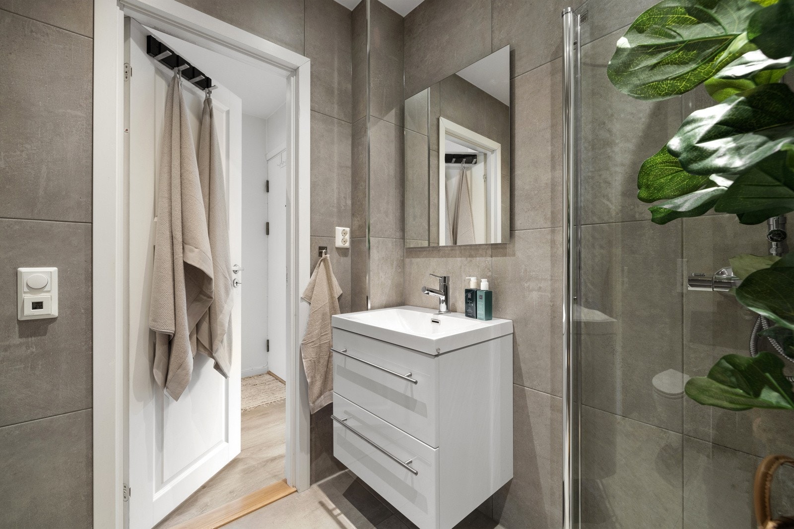 Moderne baderomsinnredning med speil i overkant, varme i gulvet og elektrisk avtrekksvifte. Galleribilde