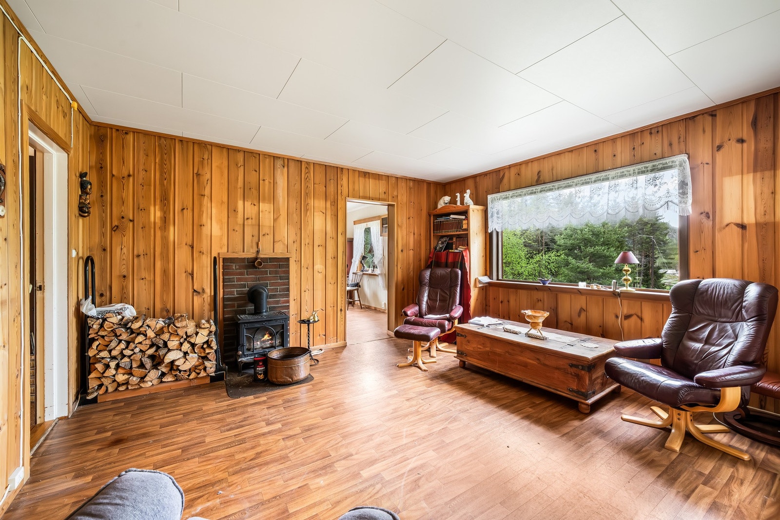 I stua er det store vinduer som slipper inn masse dagslys og gir en flott utsikt utover eiendommen Galleribilde