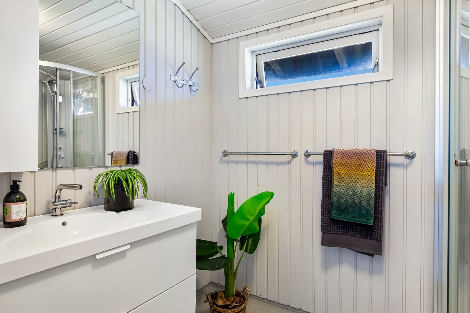 Badet som er tilknyttet hovedsoverommet har toalett, dusjkabinett og servant med skuffer under. Galleribilde