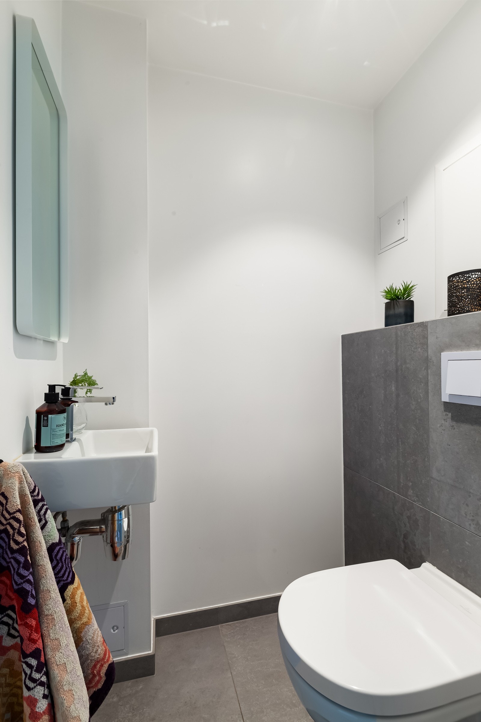 Toalettet er plassert i et eget rom vegg i vegg med badet. Her er det vegghengt toalett og vegghengt servant. Galleribilde