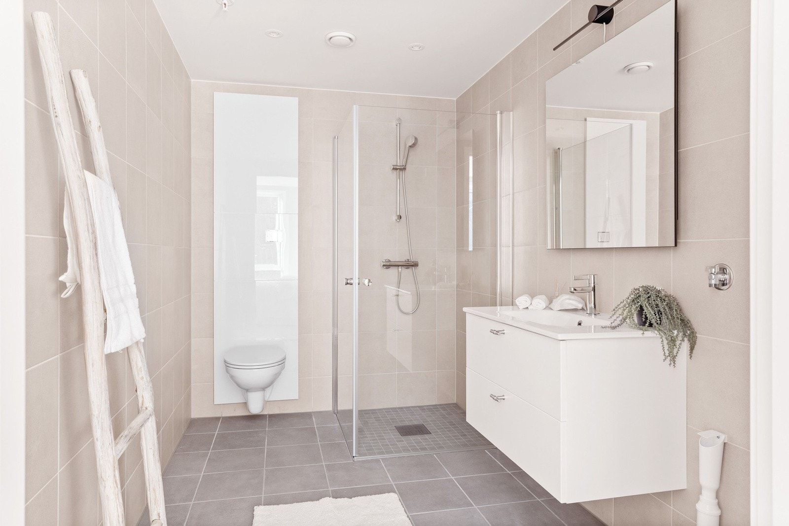 Romslig og pent flislagt bad med elektriske varmekabler i gulv og opplegg for vaskemaskin. Galleribilde