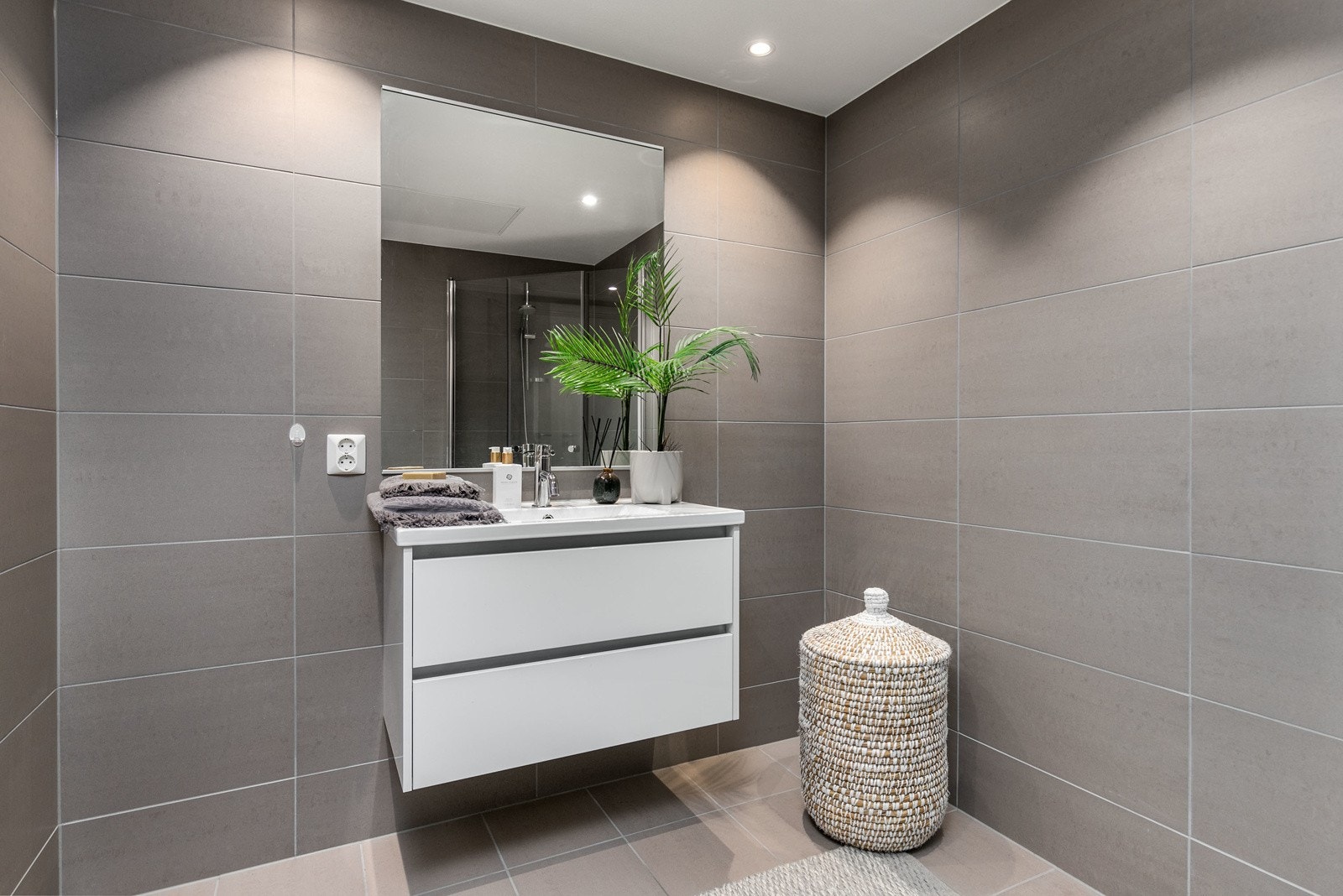 Delikat og smakfullt bad med flislagte overflater og med varme i gulv Galleribilde