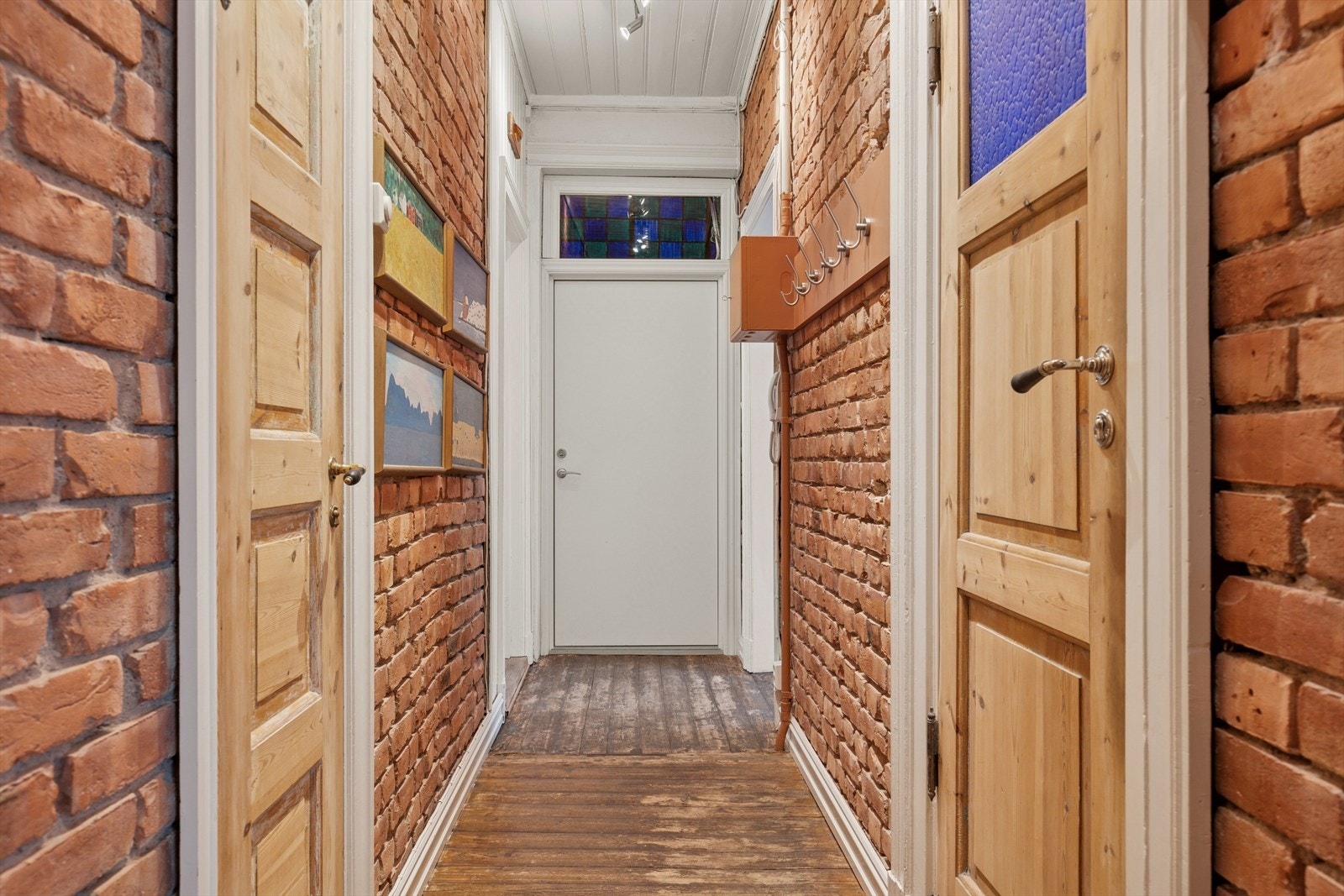 Du blir møtt av en velholdt og praktisk entré med originale furugulv, teglsteinsvegger og god takhøyde. Det er god plass til å henge fra seg yttertøy og sette fra seg skoene her. Galleribilde