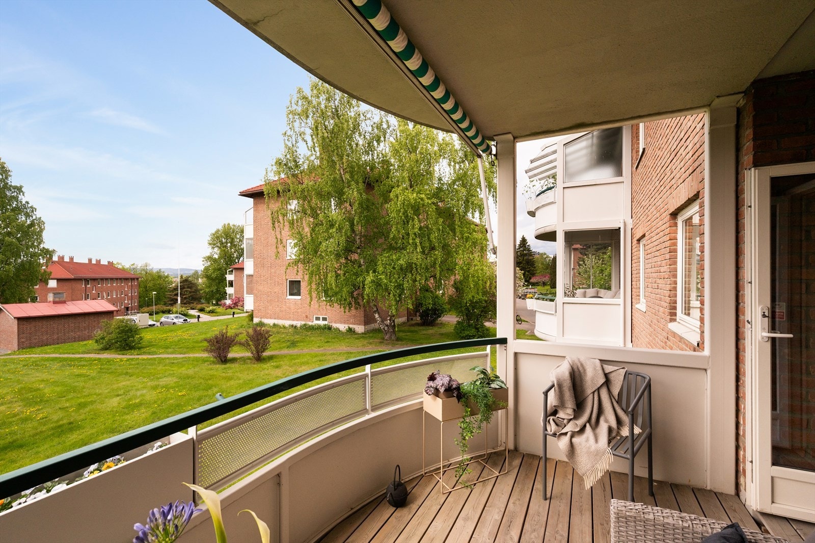 Balkongen har tregulv lagt over betongdekke, markise for solskjerming og god plass til utemøbler. Galleribilde
