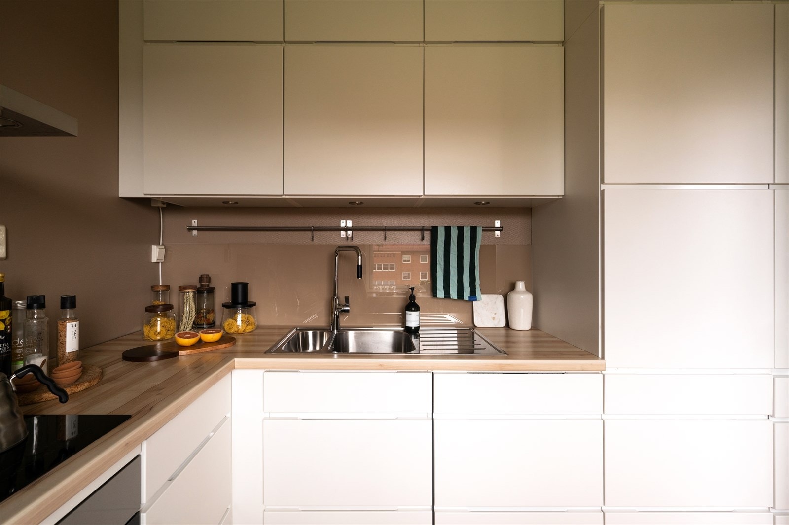 Pent og funksjonelt Kvik-kjøkken fra 2015 med hvite, glatte fronter og laminert benkeplate. Galleribilde