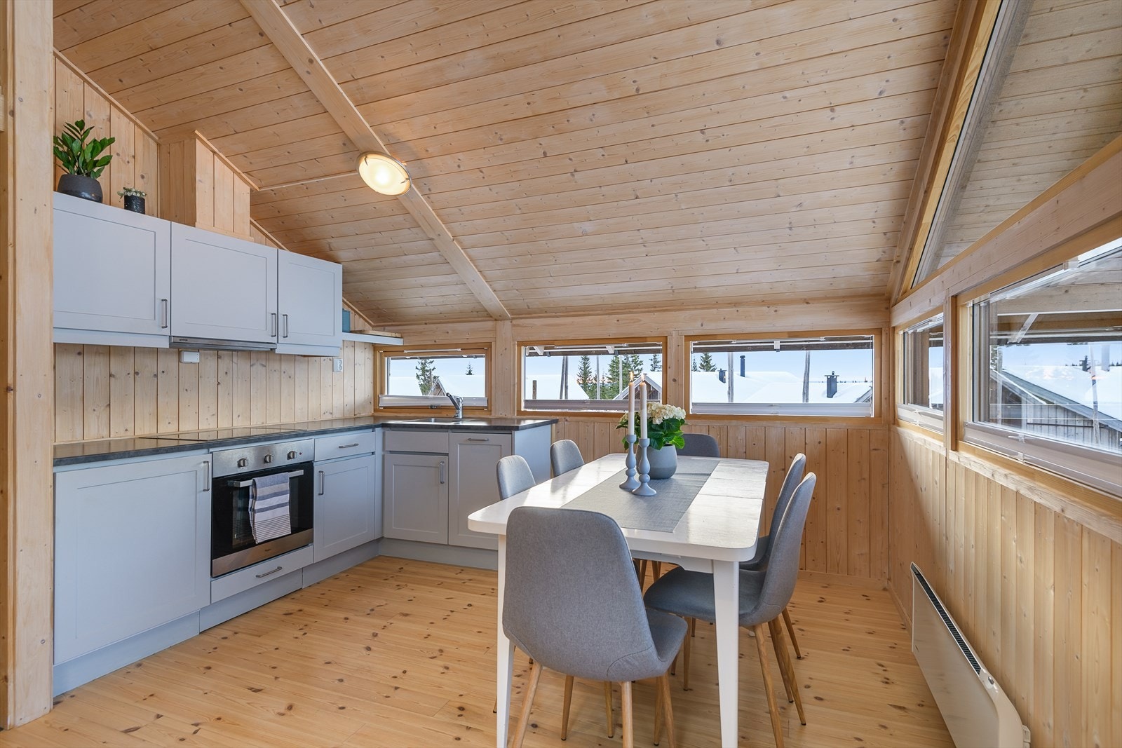 Kjøkkenet har innredning i en tidløs og delikat gråtone. Rikelig med godt lys inn i rommet gjennom vinduene. Galleribilde