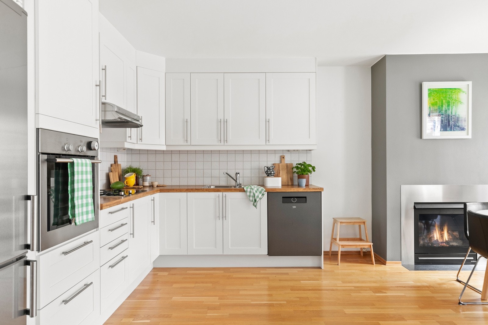 Kjøkken med profilerte fronter i hvit utførelse og benkeplate i laminat. Galleribilde