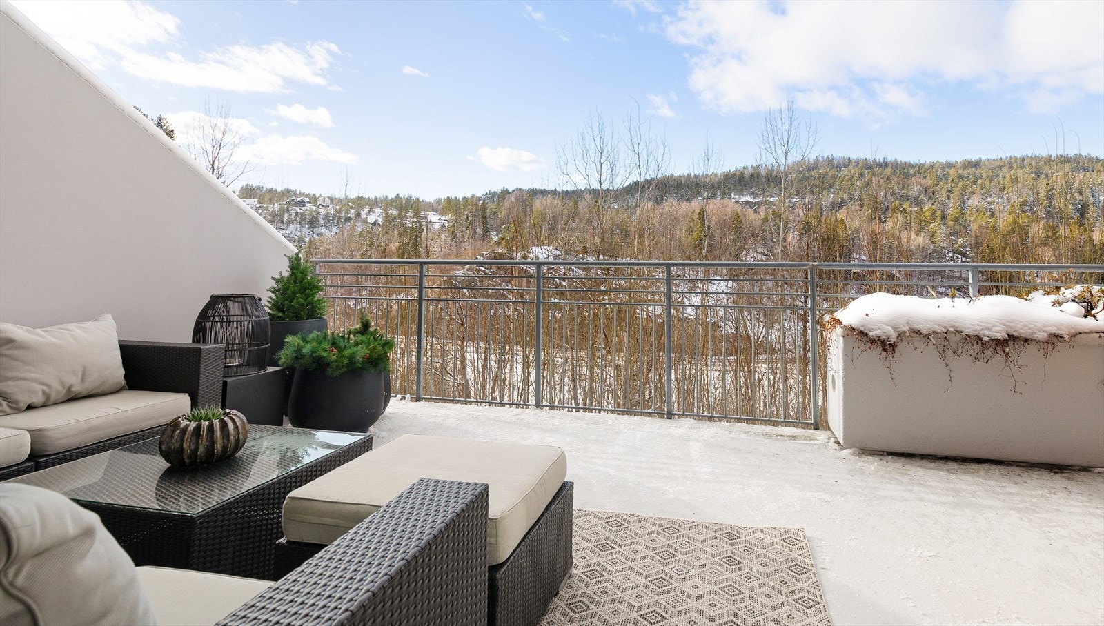 Stor og innbydende uteplass med fin utsikt! Den er delvis overbygget, utstyrt med motorisert markise, utebelysning og stikkontakt, samt adkomst til en praktisk utvendig bod. Galleribilde