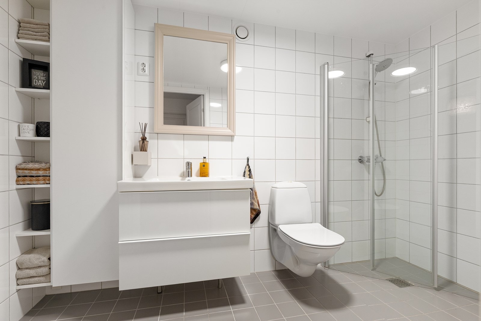 Lyst og funksjonelt flislagt bad med varmekabler, samt nyere servantskap og høyskap. Galleribilde