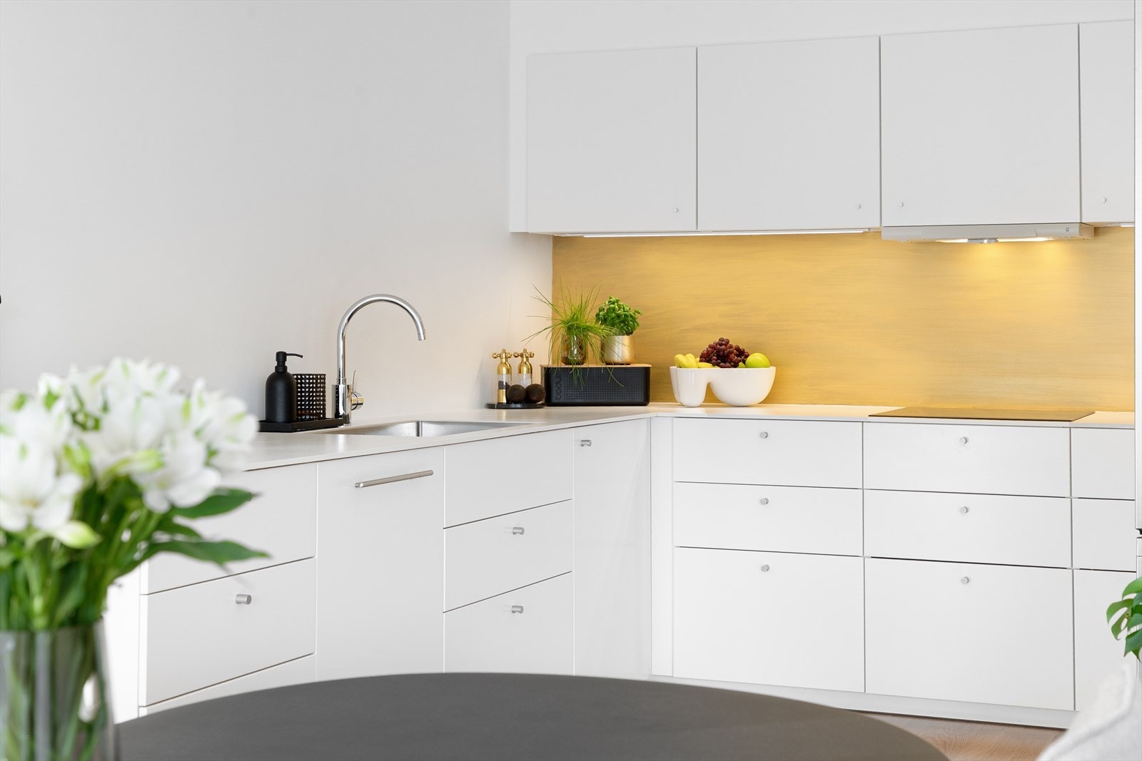 Benkeplate i slitesterkt komprimert laminat, og 70 cm bred nedfelt oppvaskkum i rustfritt stål med svingbart blandebatteri i krom. Galleribilde