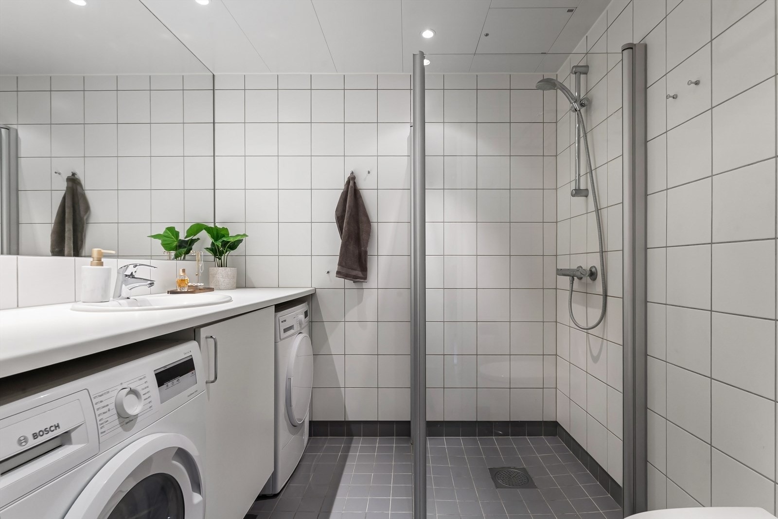 Delikat baderom fra byggeår med varmekabler og opplegg for vaskemaskin. Galleribilde