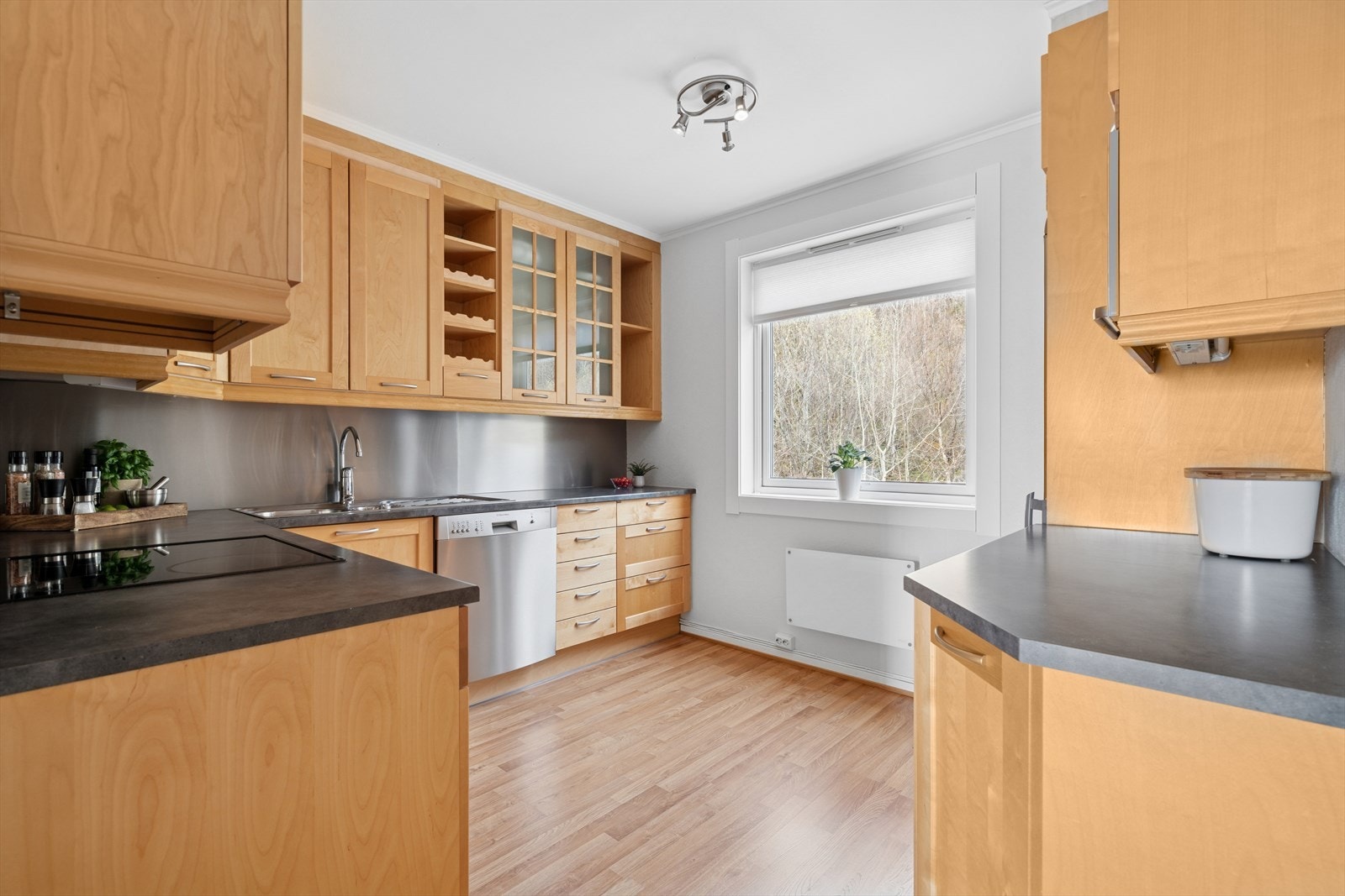 Lyst kjøkken med profilerte bjørkefronter og benkeplate av typen laminat. Galleribilde