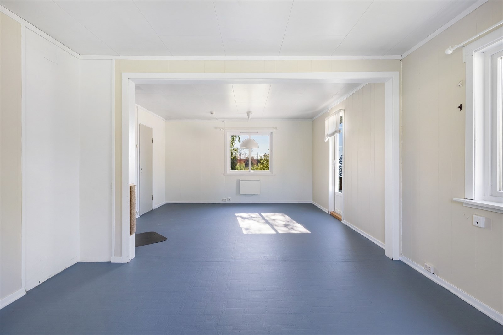 Rommet er åpent, men delt inn i to soner. Det er god plass for både sofagruppe og spisestue. Galleribilde