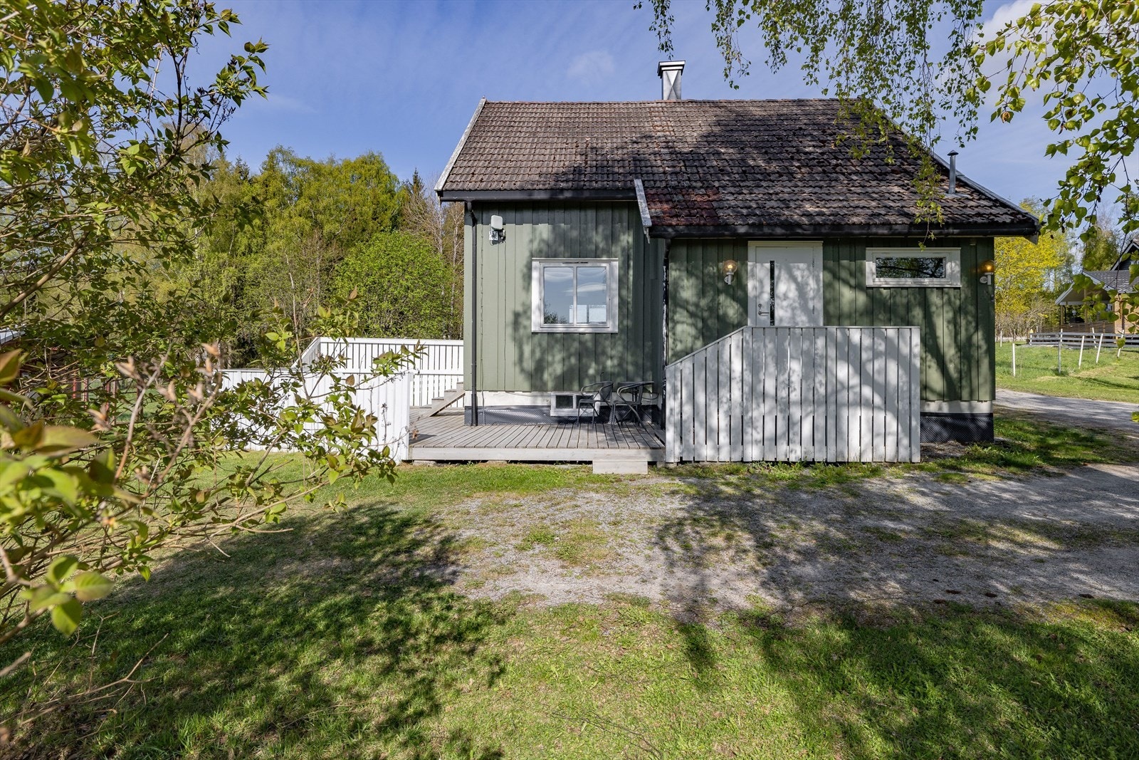 Gårdstunet og adkomstarealer er gruset. Du tar deg til boligen via terrasse og trapp opp til inngangsdøra. Galleribilde