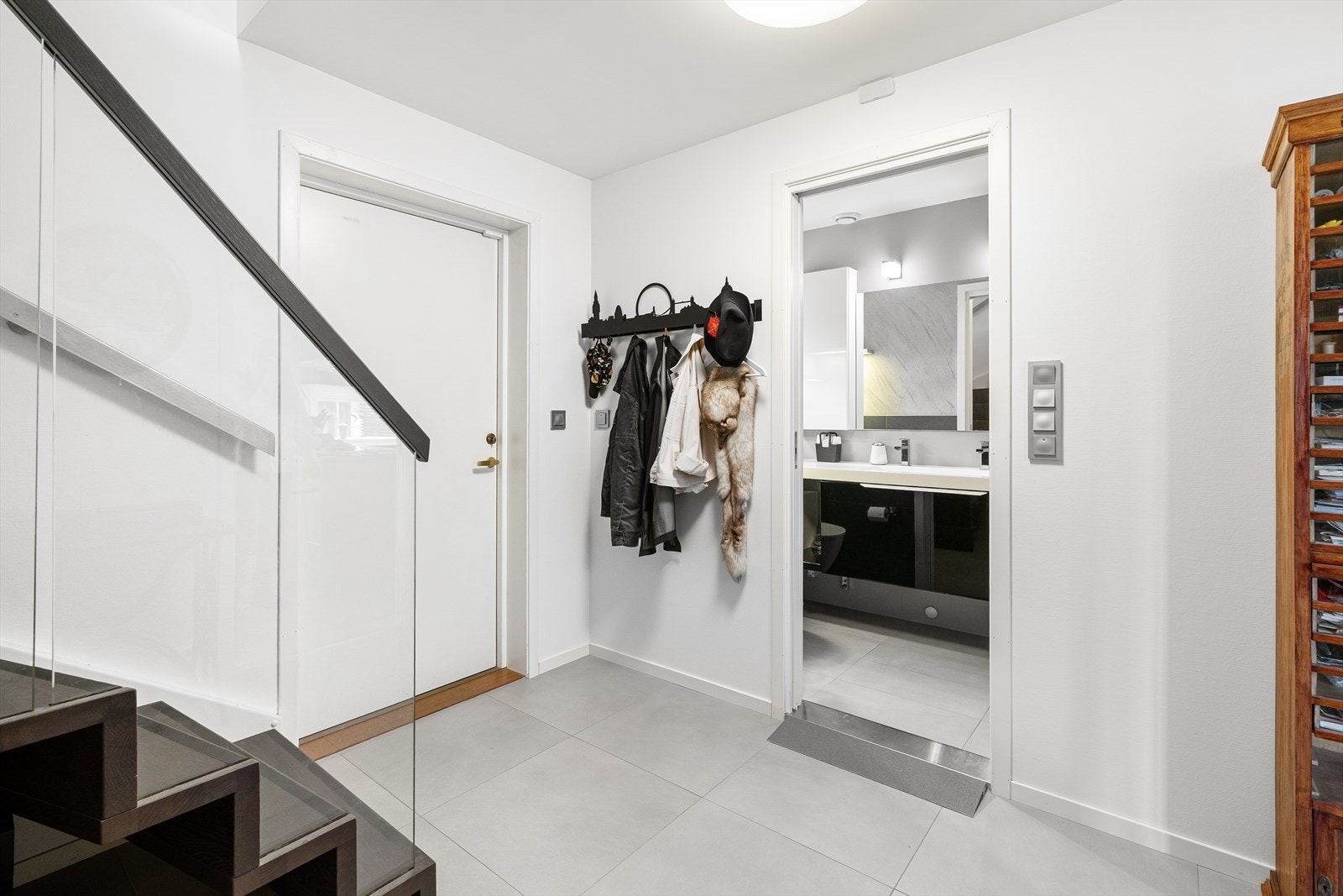 Entreen har skyvedørsgarderobe med speilfronter og en plassbygd benkeplate under trappen, samt plass til andre garderobeløsninger. Galleribilde