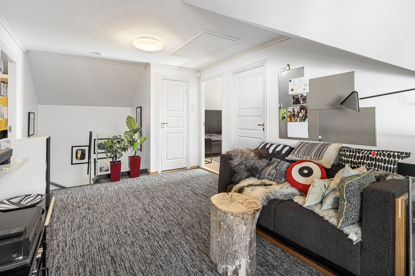 Stuen har teppe på gulvet, skråtak og lysmalte veggflater, samt god plass til sofagruppe og tv-løsning med mer. Galleribilde