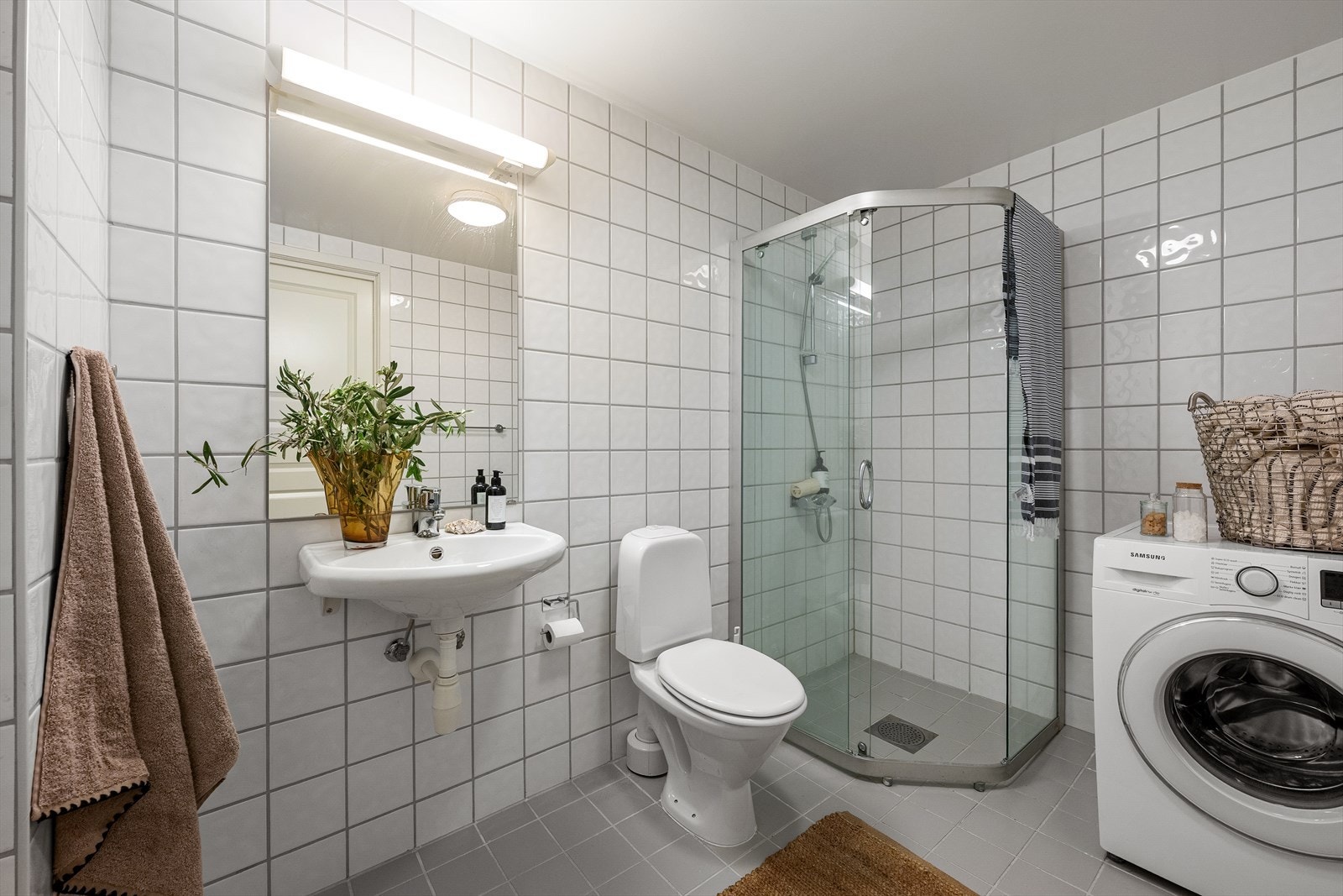 Lyst og pent bad med opplegg for vaskemaskin og tørketrommel Galleribilde