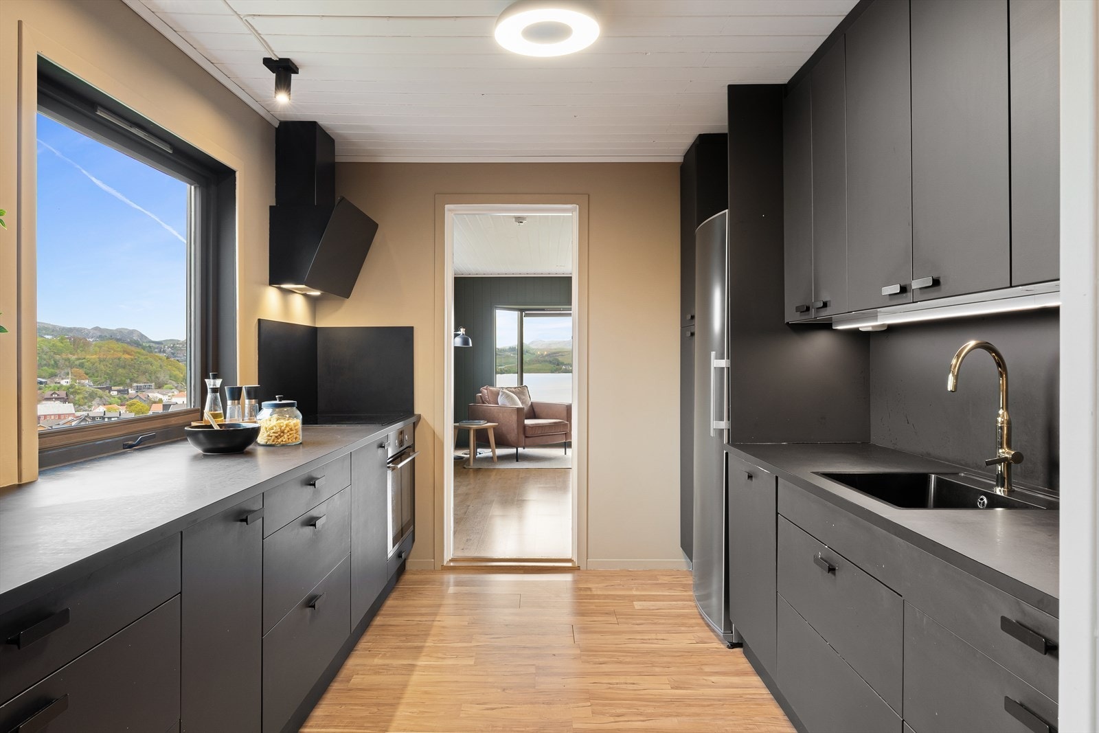 Kjøkkenet ble pusset opp i 2020 med nye fronter og benkeplate og fremstår moderne og funksjonelt med stilrent svart kjøkkeninnredning. Galleribilde