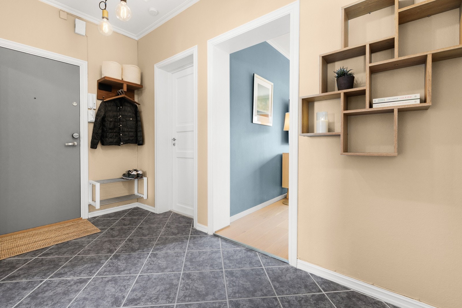 Romslig entré med praktiske fliser med varmekabel i gulvet.Entréen gir rom for små praktiske oppbevaringsmøbler eller sittemøbel. Galleribilde