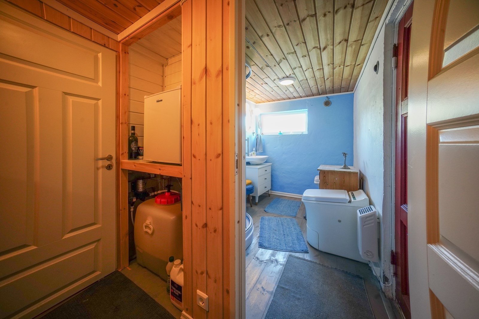 I gangen nede er vanntanken installert, og det er plass til en enkel fryseboks. Fra badet er det adkomst ut til uteboden. Galleribilde