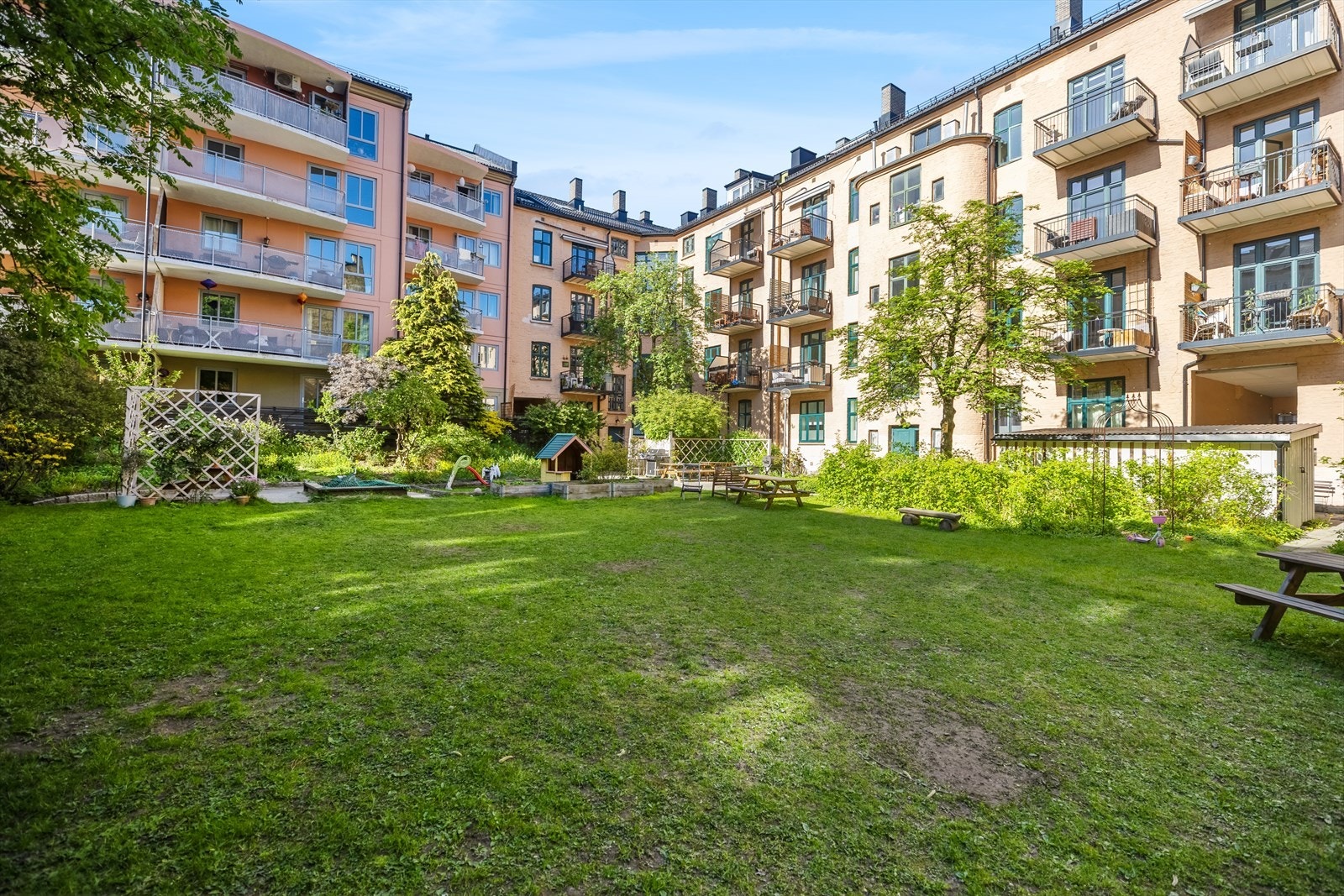 Stor bakgård med sittegrupper, plen og beplantning Galleribilde