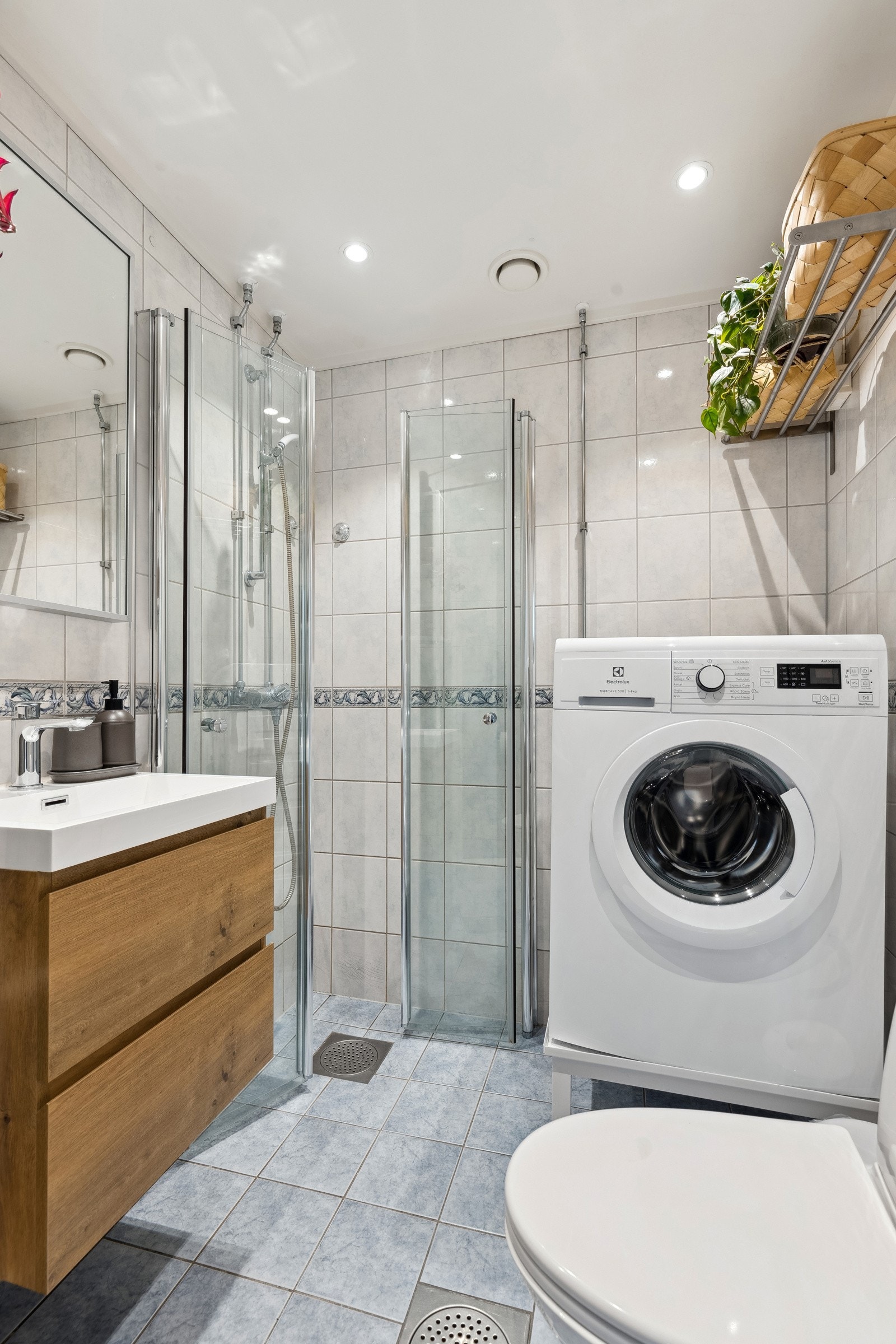 Det er toalett, servant med skap, overskap med speilfronter og dusjhjørne. Galleribilde