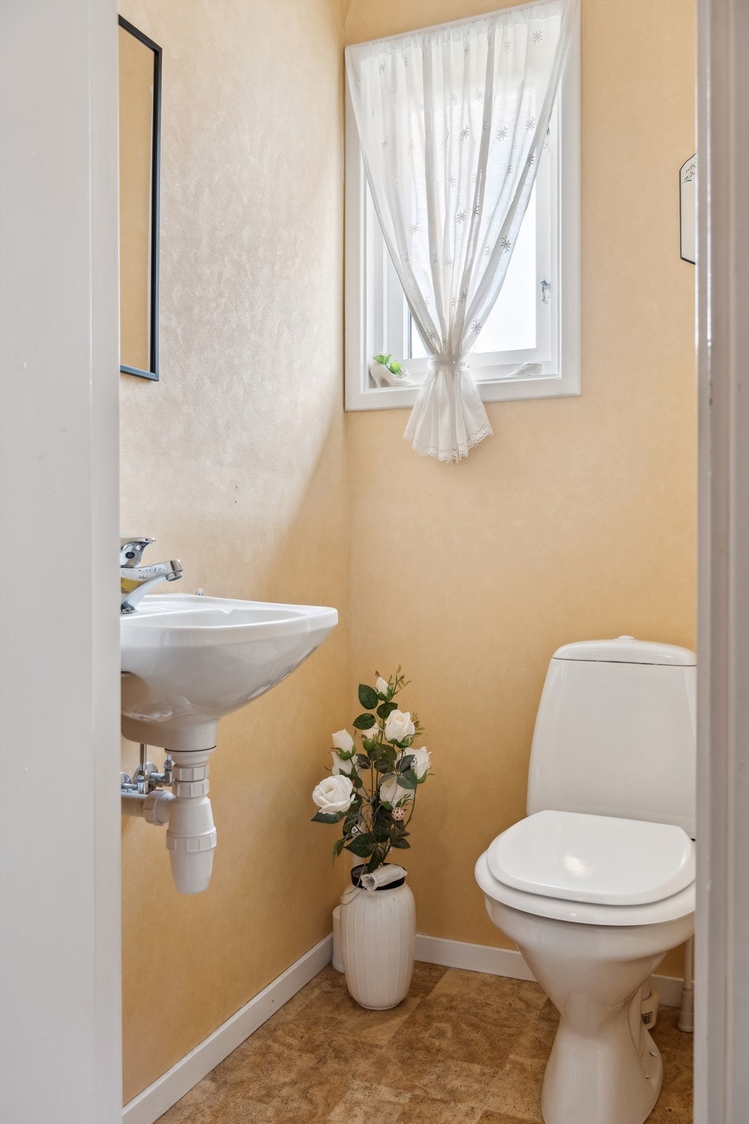 Toalettrom fra byggeåret med gulv belagt med vinyl og vegger med malte plater. Innredet med gulvmontert toalett og vegghengt servant. Oppvarming via stråleovn Galleribilde