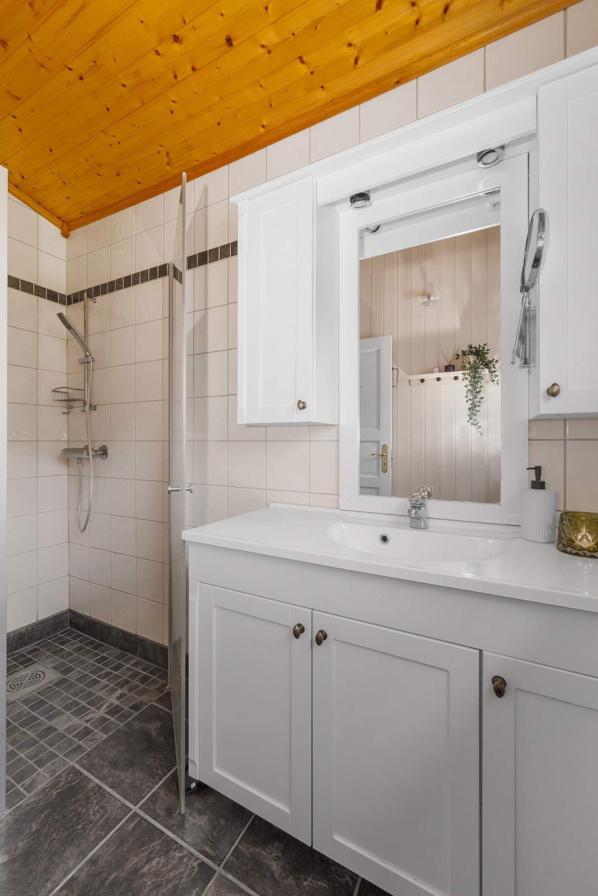 Badet er pent med fliser på gulvet og i våtsonen, gulvvarme, dusjnisje og moderne komfort. Galleribilde