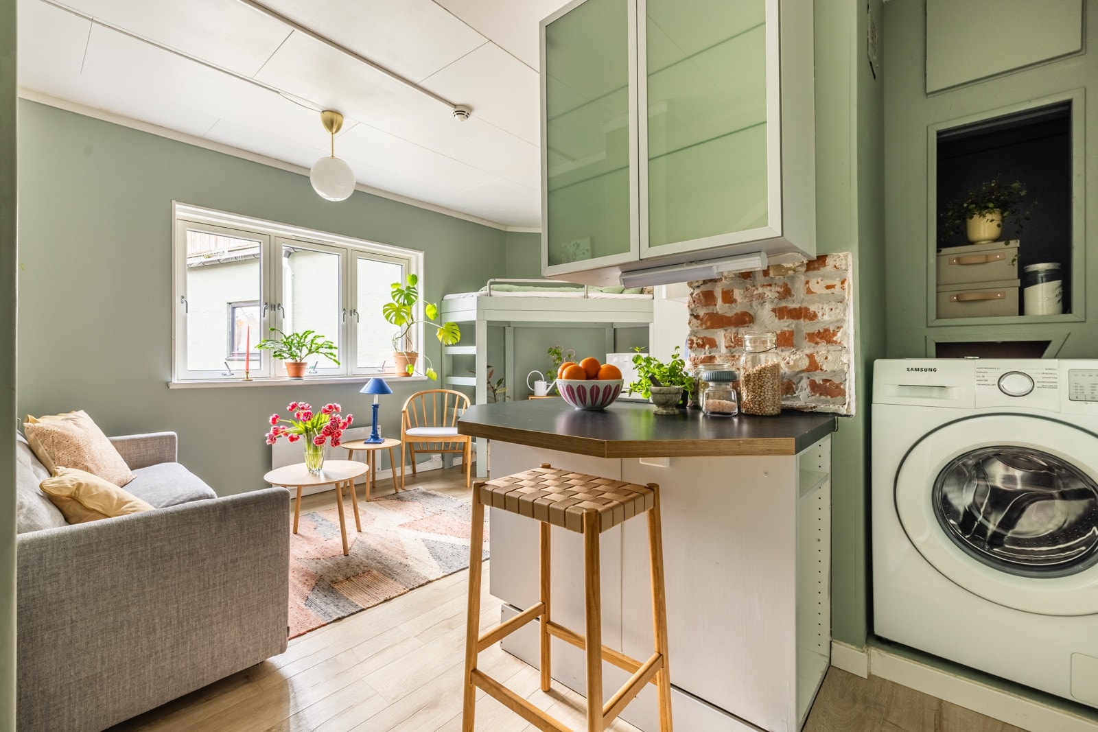 I nisjen bak kjøkkenet er vaskemaskinen plassert og praktiske hyller gir lagringsplass. Galleribilde