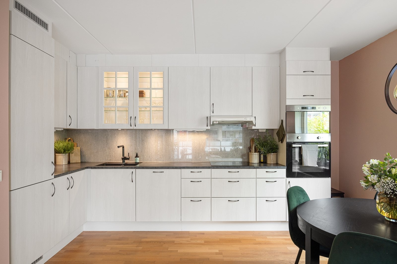 Pent og funksjonelt kjøkken med innredning fra Aubo, med glatte laminerte fronter og god oppbevaringsplass i skuffer og skap. Galleribilde