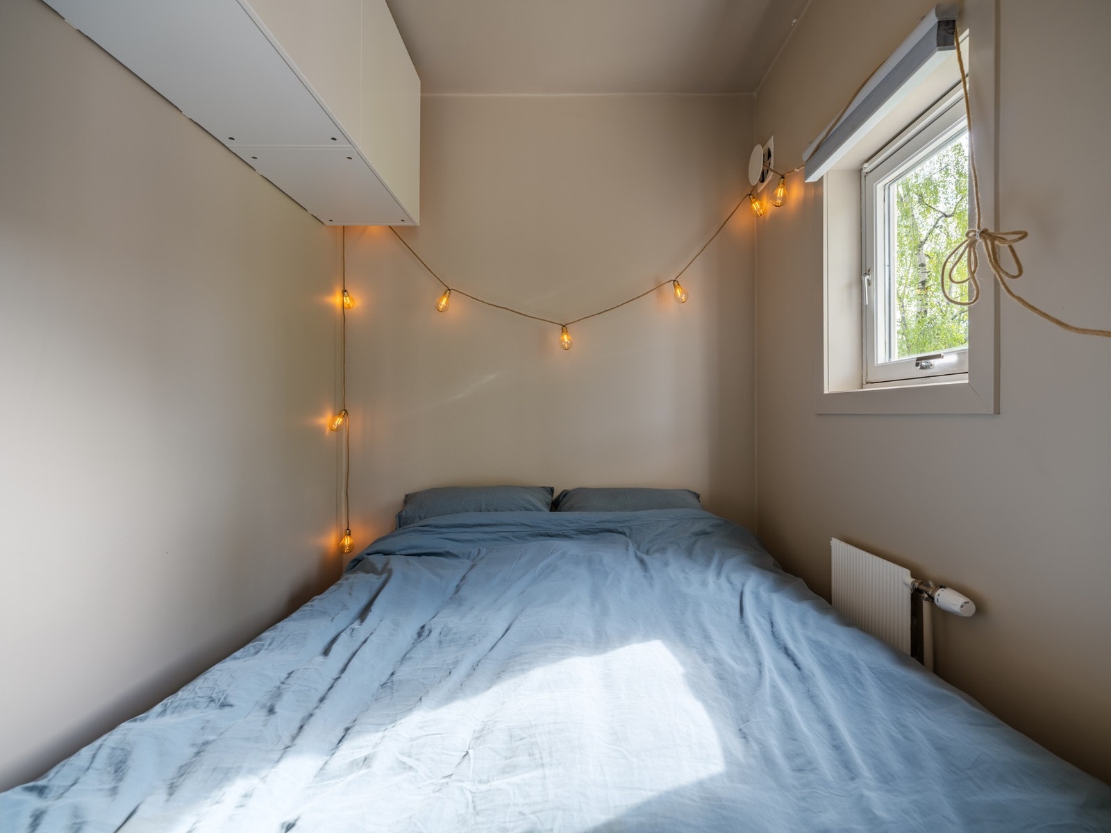 Fra stuen og kjøkkenet finner vi inngangen til sovealkoven. Alkoven er innredet med overskap med plass til oppbevaring. Vinduet slipper inn naturlig lys og luft. Galleribilde