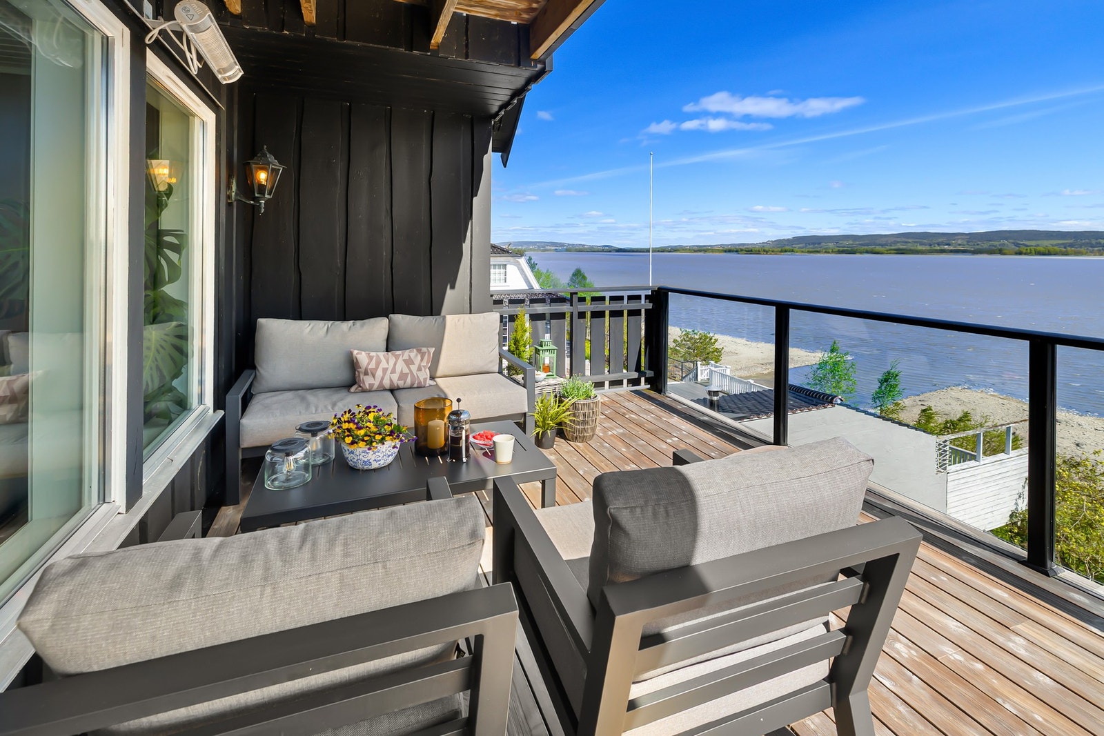 Bjelkelag med terrassebord og rekkverk av stål, blendet med glass og trebord Galleribilde