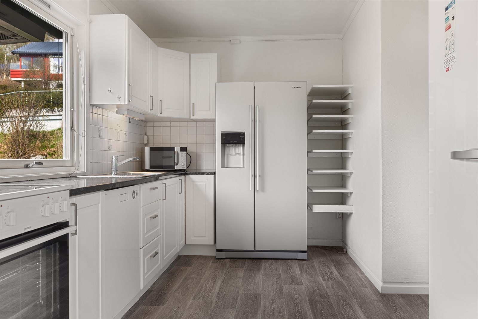 Kjøkkeninnredning med under- og overskap og laminert benkeplate. Hvitevarer medfølger. Galleribilde