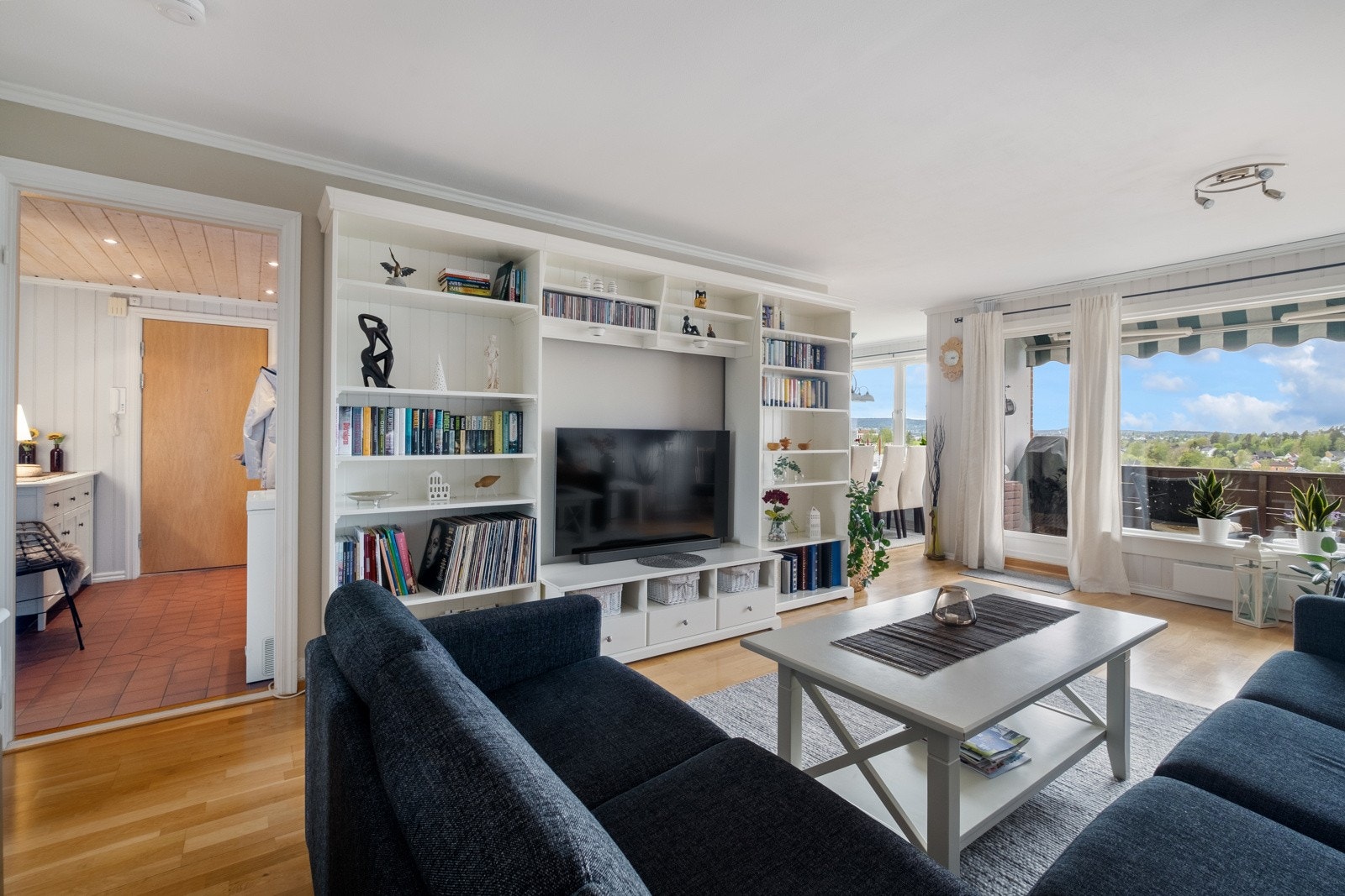 Stuen har lysmalte panelvegger, parkettgulv og flott utsikt fra vinduene. Galleribilde