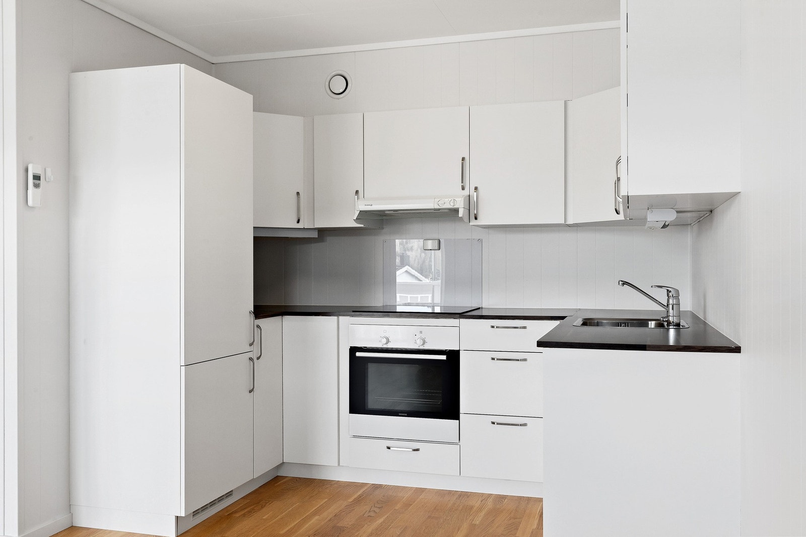 Stilren kjøkkeninnredning med integrerte hvitevarer - Integrert kombiskap, platetopp, stekovn og oppvaskmaskin. Galleribilde