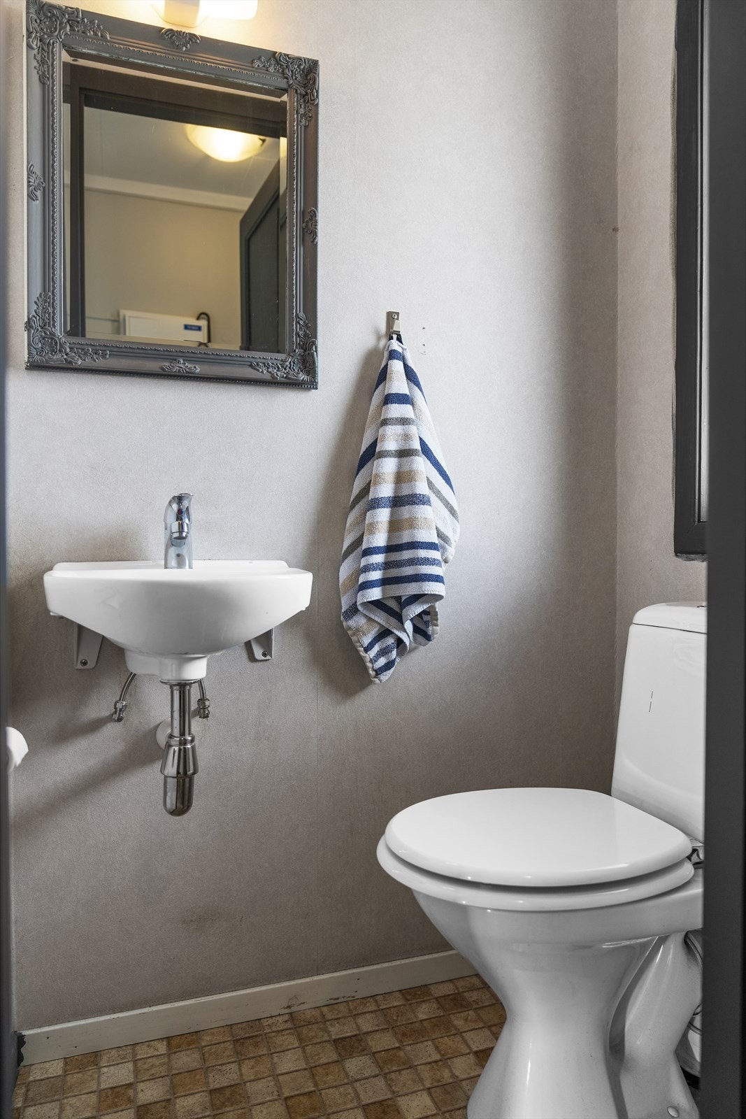 Separat toalettrom med belegg på gulv og tapet på vegger. Takess i himling. Utstyrt med toalett, servant og naturlig avtrekk Galleribilde