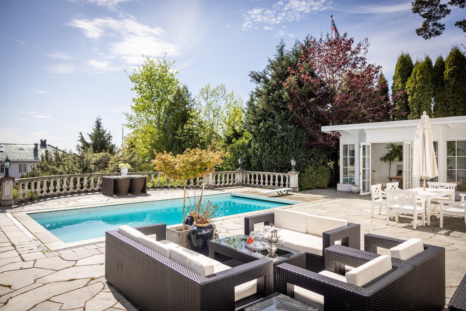 Flott terrasseområde med stort basseng og lysthus Galleribilde