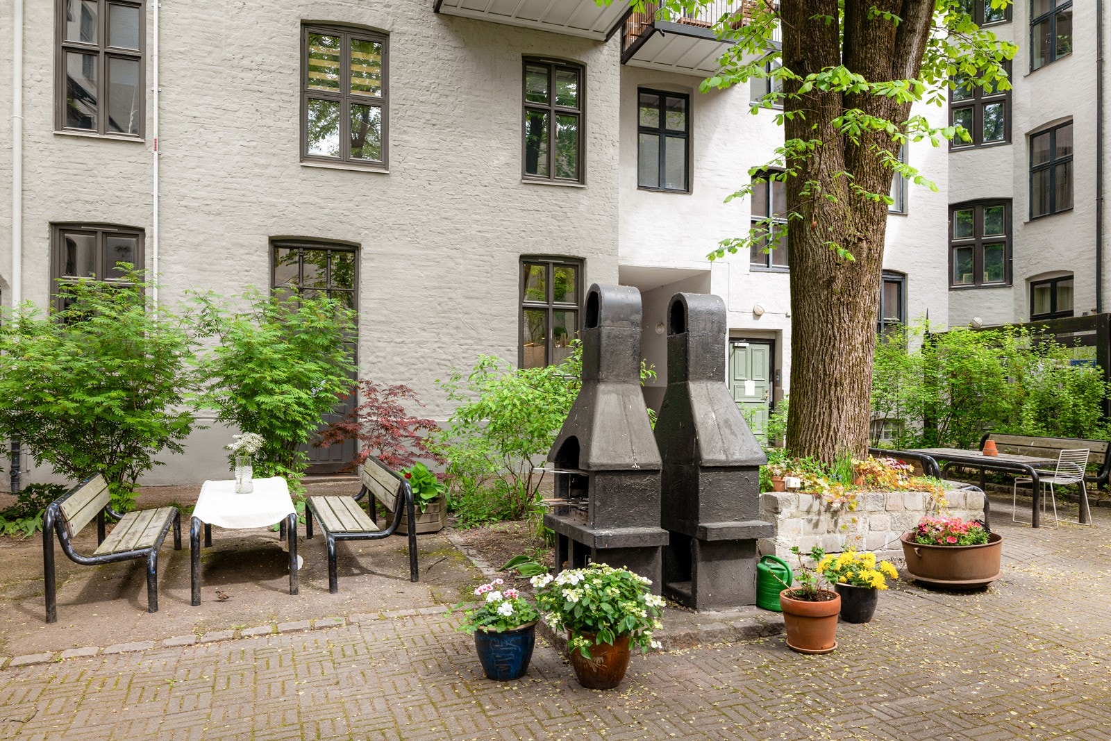 Koselig bakgård med sittegrupper og grill. Galleribilde