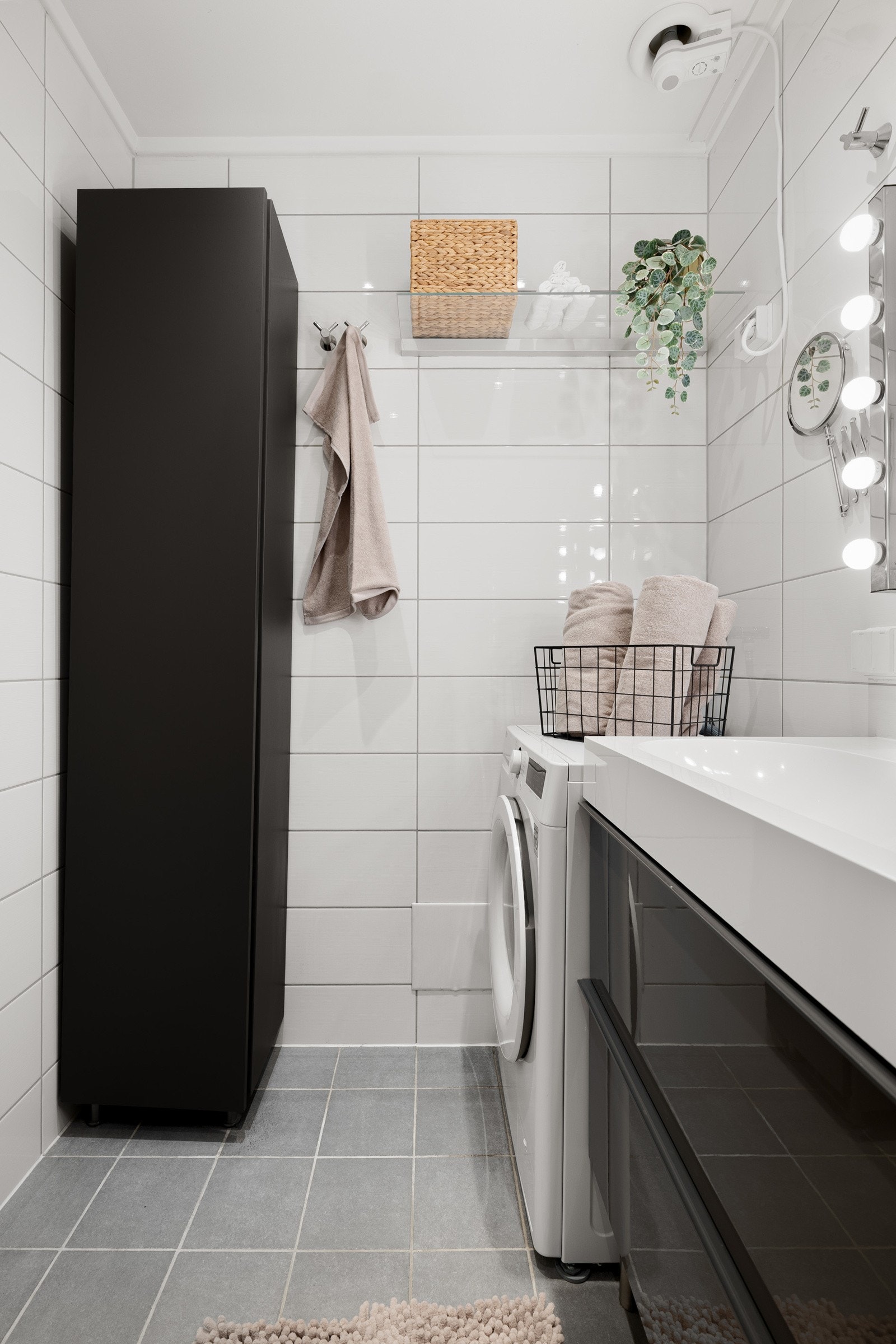 Badet inneholder vegghengt innredning med skuffer og heldekkende servant, speil med belysning, vegghengt toalett og dusjhjørne med innfellbare dører i glass. Galleribilde