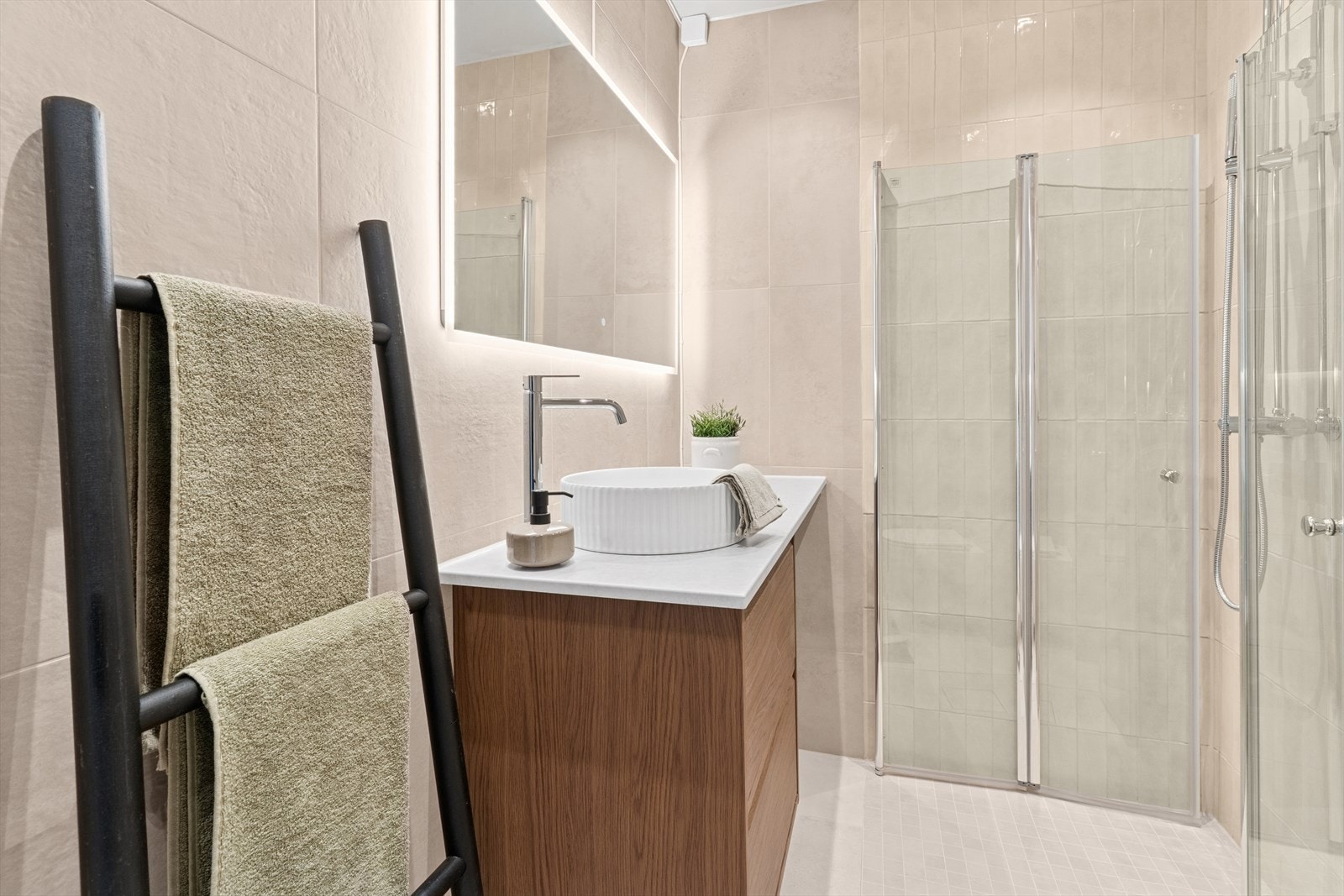 Baderommet fremstår som både delikat og innbydende, med flislagte overflater, downlights i himlingen og behagelig gulvvarme som sørger for ekstra komfort i hverdagen. Galleribilde