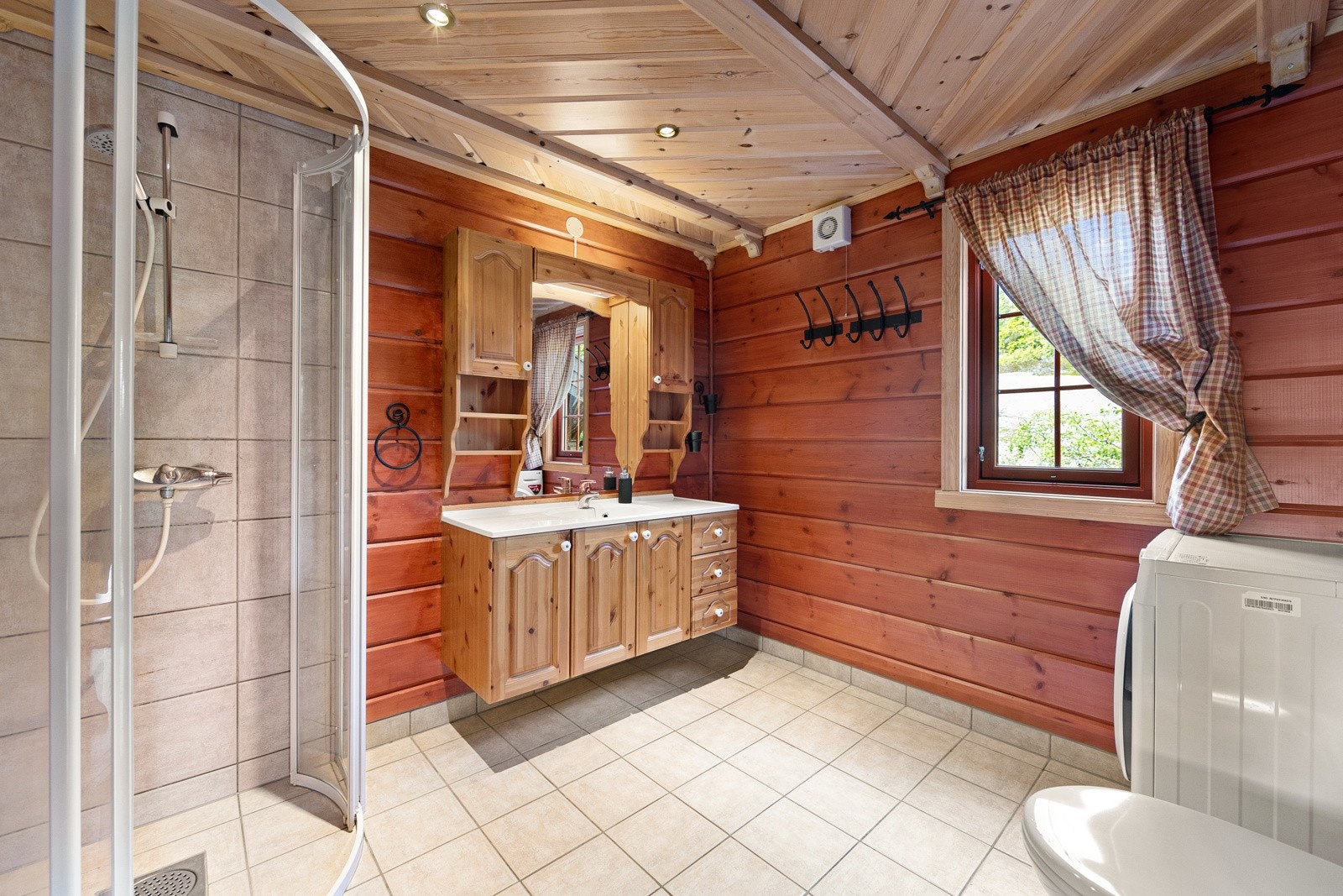 Klassisk flott hyttebad med flislagte gulv og dusj-sone. Galleribilde