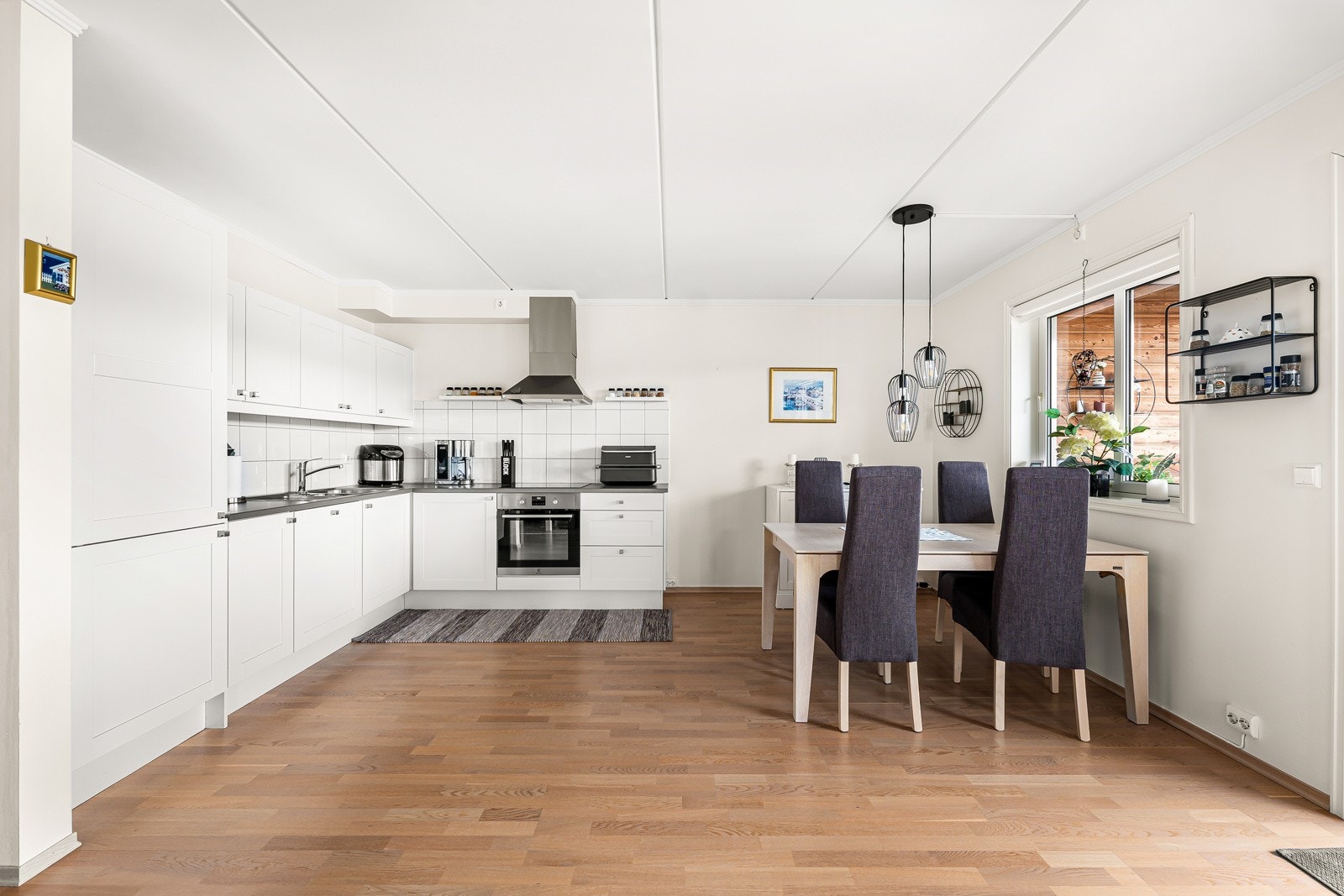 Stue og kjøkken ligger i åpen løsning, men kjøkkenet er smart tilbaketrukket, som gir et naturlig skille i rommet. Galleribilde