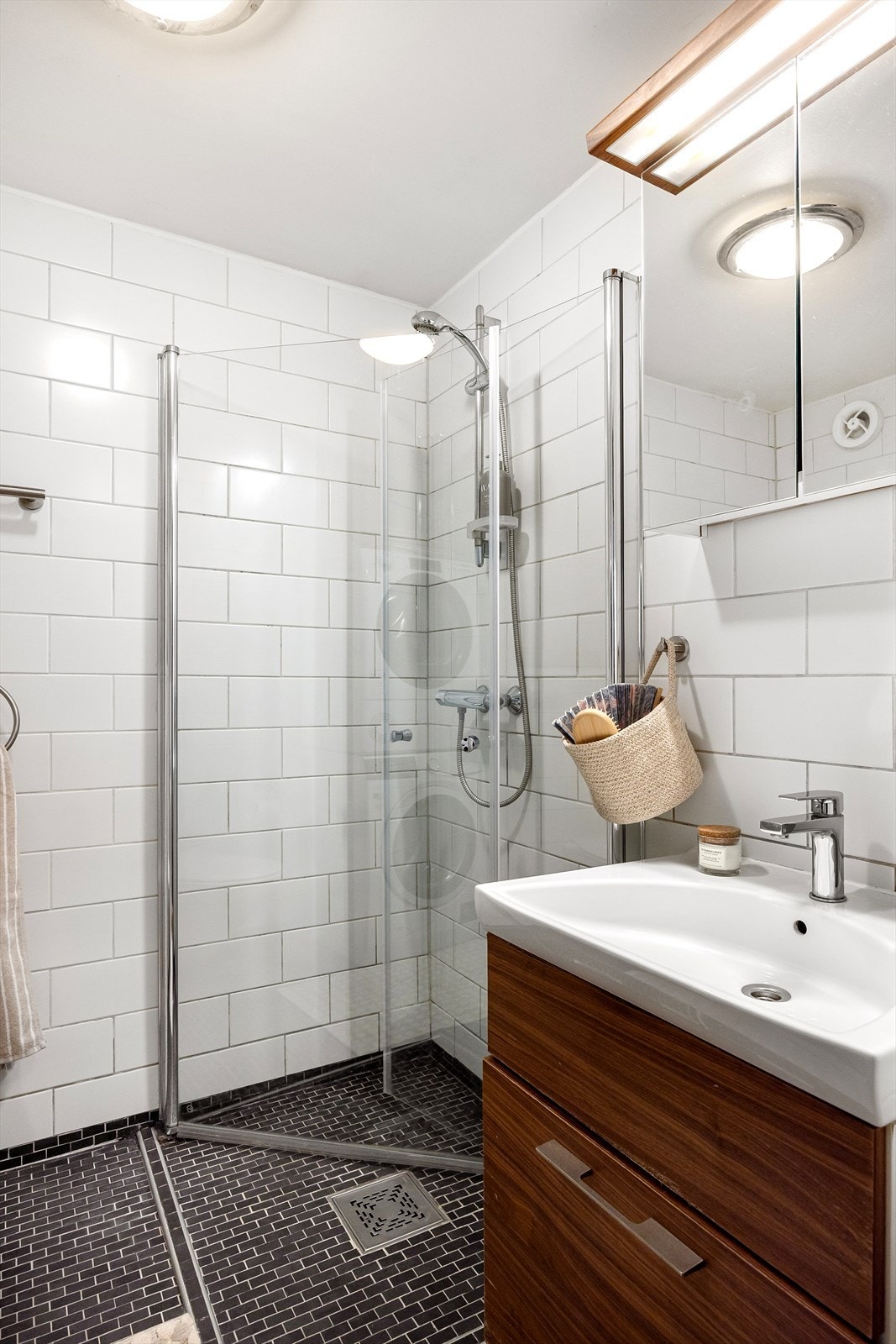Badet fremstår som moderne og stilrent, oppusset i 2009 med gjennomtenkte løsninger. Det er utstyrt med dusjnisje med innfellbare glassvegger, vegghengt toalett, servant med underskap og speilskap med integrert belysning. Galleribilde