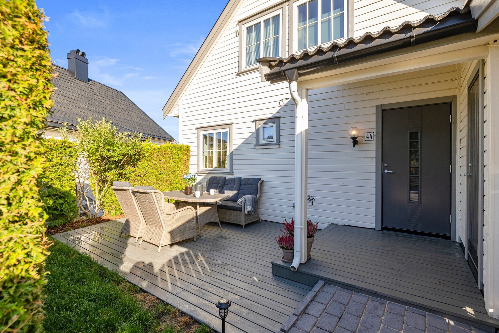 Inngangspartiet er fint opparbeidet med platting som ble slipt og beiset i 2024. Den tette hekken sørger for at ingen ser deg heller. Galleribilde