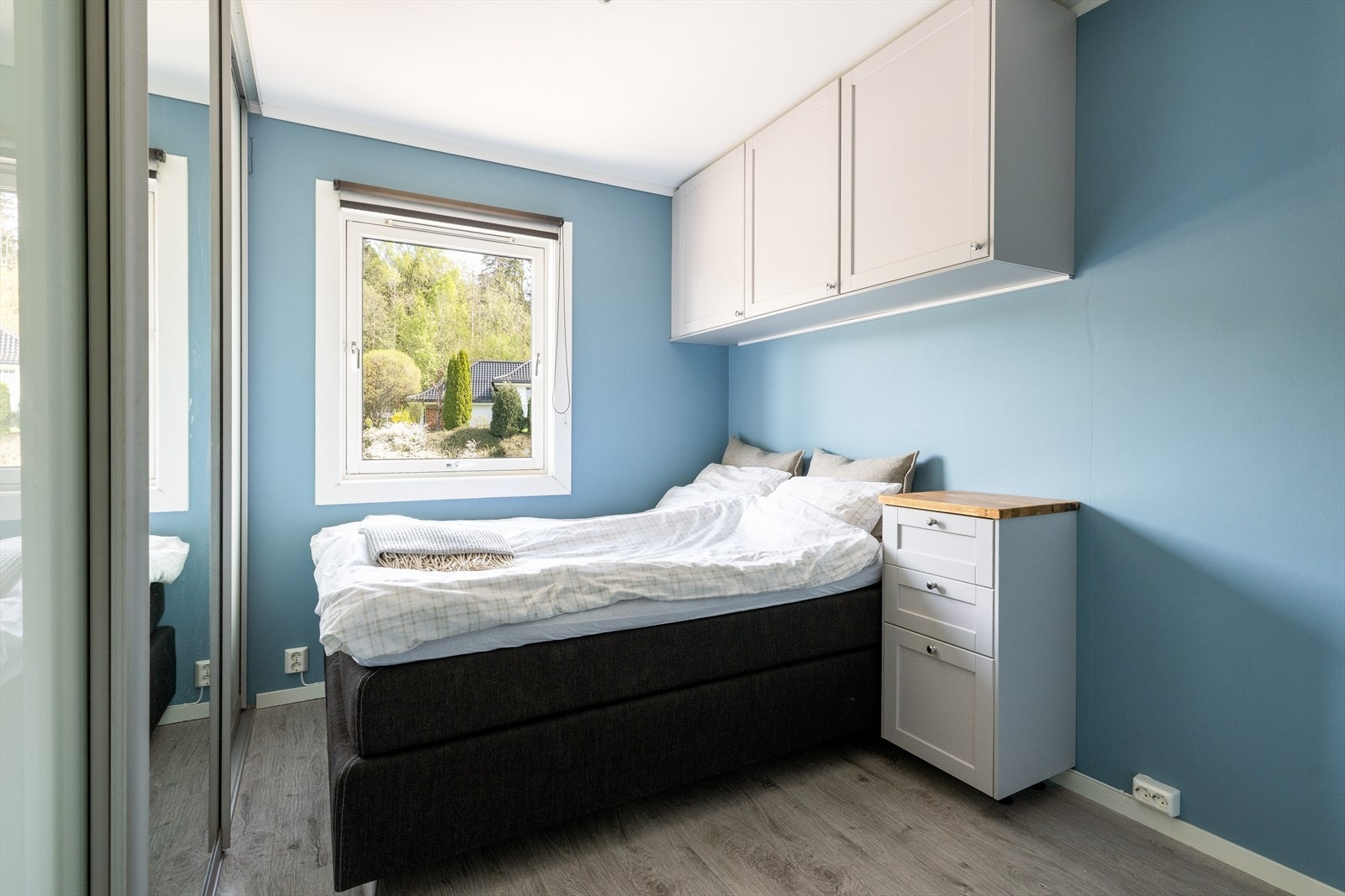 Leilighetens soverom er malt i en behagelig farge og har et vindu som sliper inn rikelig med naturliglys. Galleribilde