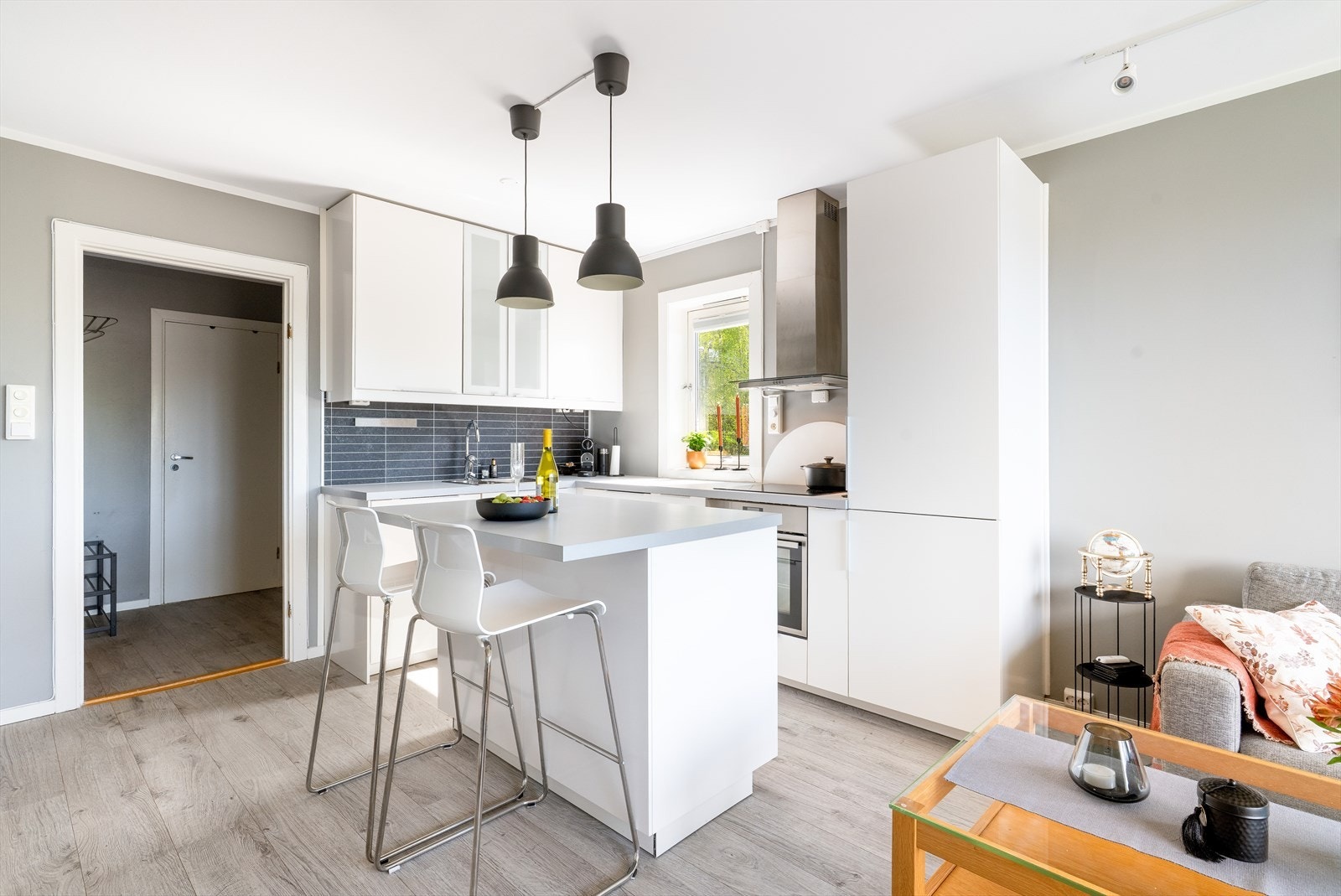 Flott kjøkkeninnredning fra IKEA med slette lyse fronter samt noe glass på overskapene. Innredningen har god skapplass og fuktbestandige plater på vegg mellom over og underskap. Galleribilde