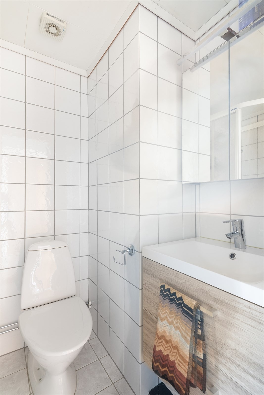 Baderommet har overflater bestående av flis på vegger, flislagt gulv med elektriske varmekabler samt malte slette flater i himling. Galleribilde